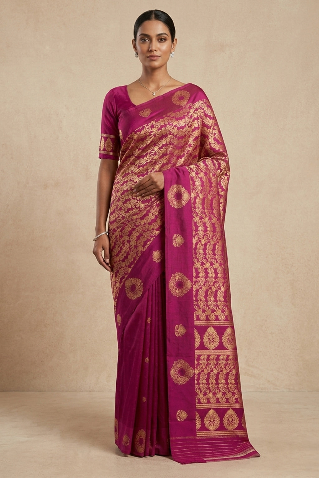 Model wearing a Anaar, woven in silk with a satin border, highlights the intricacy of kadhua weaving accented with meenakari. Designed in a half-and-half layout, the saree features delicate pomegranate butas on one half and a flowing pomegranate jaal on the other. Alternating satin border motifs and a jaal-led pallu, divided by a row of butas, lend rhythm and balance, drawing from the organic stylisation of Art Nouveau.
