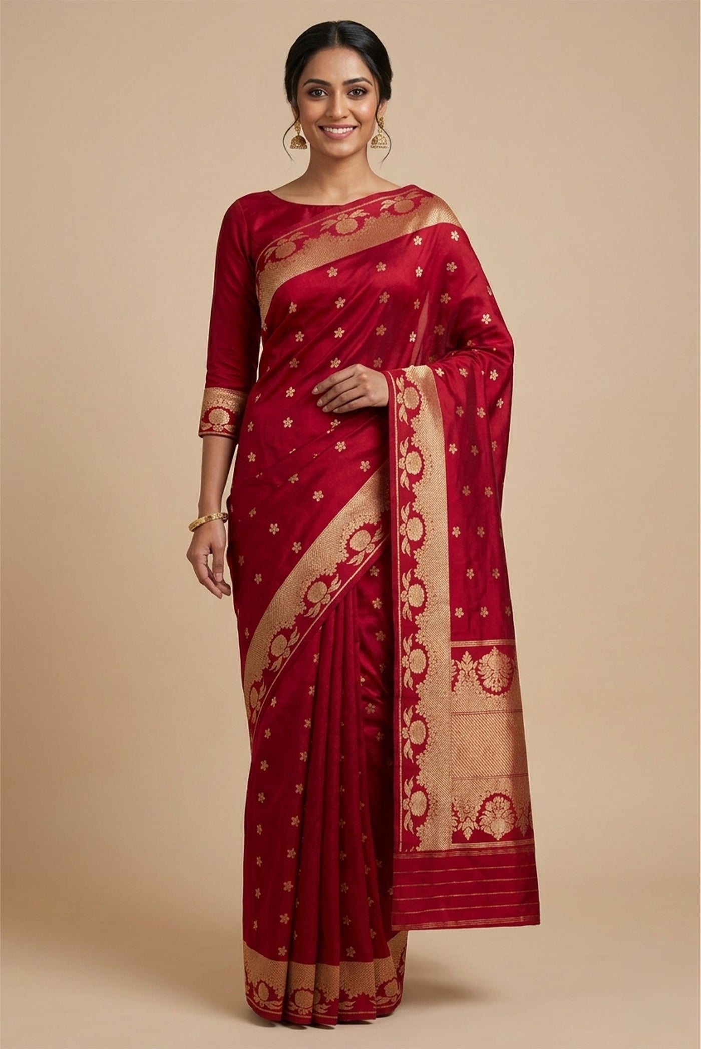 Model wearing a Gulal, handwoven in Katan silk with gold zari, is crafted using the phekwa technique, allowing closely spaced motifs to emerge with precision. Tiny floral butis in a dense half-step repeat lend the body a soft, textured richness. Art Nouveau?inspired floral arches define the borders, each framing a complementary buta, while a solid gold twill pallu completes the saree with depth and classic balance.