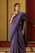 Model wearing a Patang features fine multi-coloured checks woven using four harmonious hues, creating a lively yet balanced design. Translating to ?te)n Hindi, the saree reflects the light, easy spirit of a patang gliding across an open sky. The border and pallu are minimal, finished with delicate zari accents that add subtle richness. With its balanced play of colour, it makes for a breathable, comfortable drape.