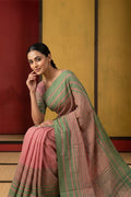 Model wearing a Titli, framed with proportioned stripes that gradually narrow towards the body, bringing together a vibrant palette in harmony. Where the border and pallu stripes meet, tiny checks appear, evoking abstract butterflies - delicate creatures of spring and summer. The plain body offers soft contrast, allowing the colours to shine. On the pallu, these stripes return as subtle checks, adding a light, balanced finish.