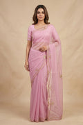 Model wearing a Meher, crafted in silk organza, is hand-embroidered with gold and antique-gold zardozi. Organic vines and floral buds form a rich border that meets at a delicate fan motif - an ornamental form celebrated in late 19th and early 20th century Art Nouveau design. Iris flowers, symbolising femininity, grace, and mystique, echo the saree?s fluid curves as the motif repeats across the body, finished with elegant gota edges.