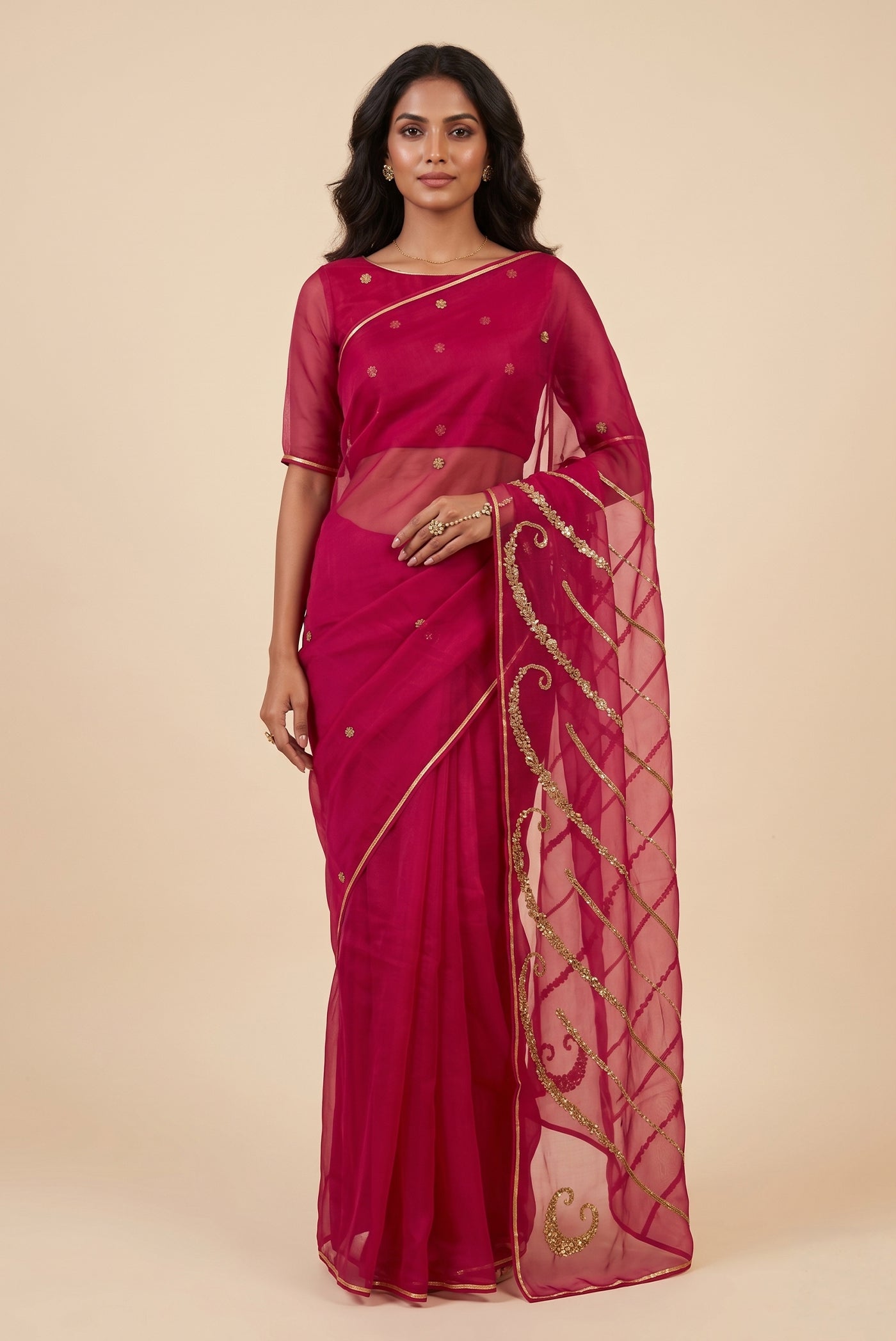 Model wearing a Sitara, crafted in silk organza and embroidered in antique-gold zardozi, draws from Art Nouveau?s love for organic, nature-led forms and the graceful contours of butterfly wings. The pallu features striking V-shaped motifs filled with floral embroidery, worked in dabka, sequins, and beads, alternating between dense and lighter forms. A minimal floral body allows the statement pallu to unfold with soft grandeur.