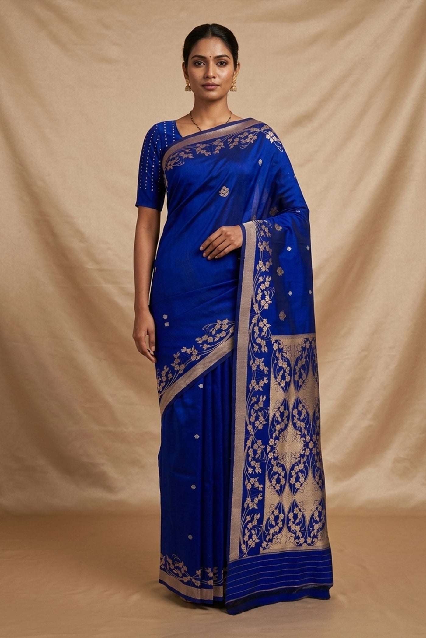 Model wearing a Gul from the collection draws from Art Nouveau curves and ornamental florals. Handwoven in Katan silk with rich gold zari using the Kadhua technique, the body features delicate floral butas and three-flower clusters. Solid twill borders hold soft wreaths of flowers and vines, while an ornate brocade pallu extends the motif in exquisite detail, an elegant expression of Banarasi craftsmanship.