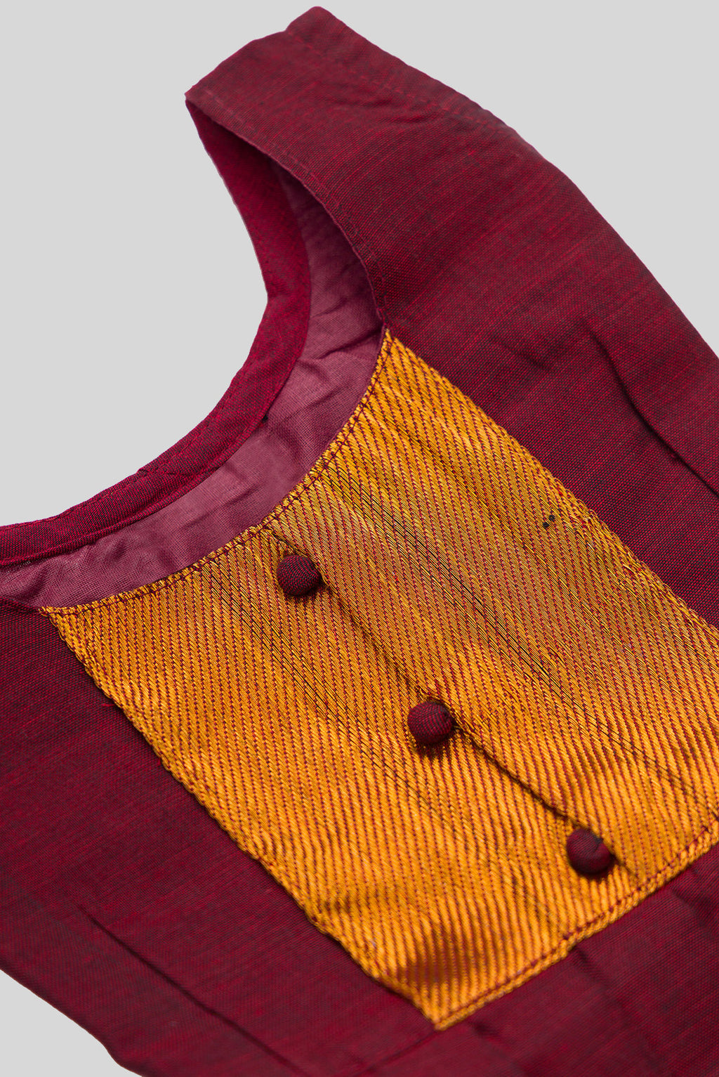 Close up blouse image of Maroon  Kids Ethnic Dress featuring a U-neck, Sleeveless Design and Plain Body Pattern with Gold Zari Detailing