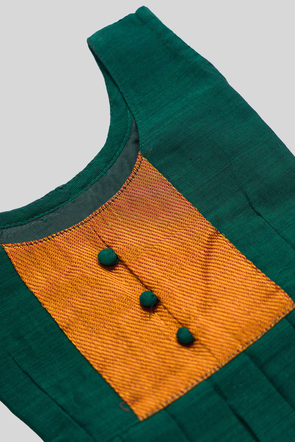 Close up blouse image of Green  Kids Ethnic Dress featuring a U-neck, Sleeveless Design and Plain Body Pattern with Gold Zari Detailing