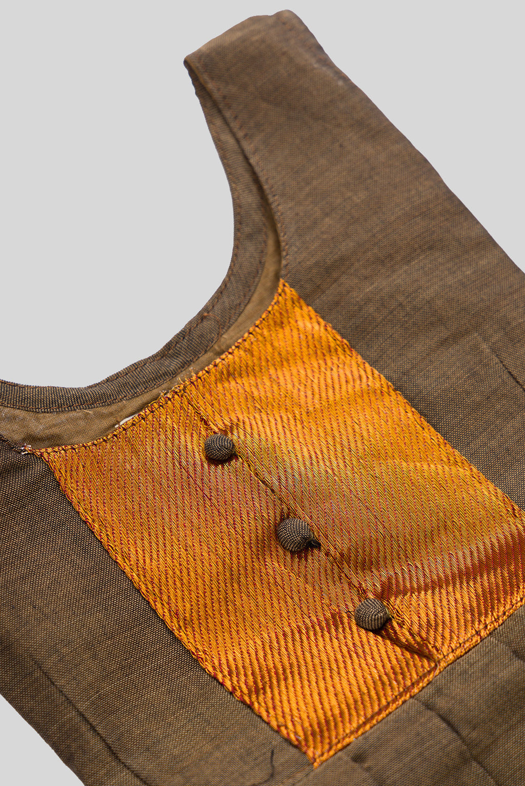 Close up blouse image of Brown  Kids Ethnic Dress featuring a U-neck, Sleeveless Design and Plain Body Pattern with Gold Zari Detailing