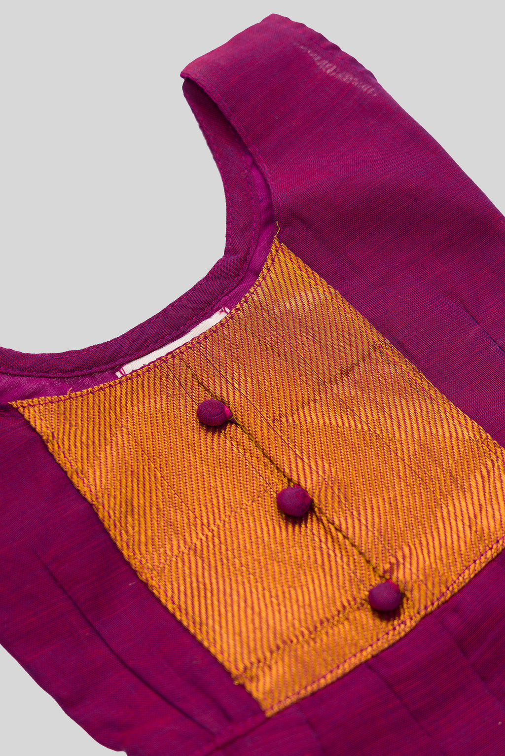 Close up blouse image of Magenta  Kids Ethnic Dress featuring a U-neck, Sleeveless Design and Plain Body Pattern with Gold Zari Detailing