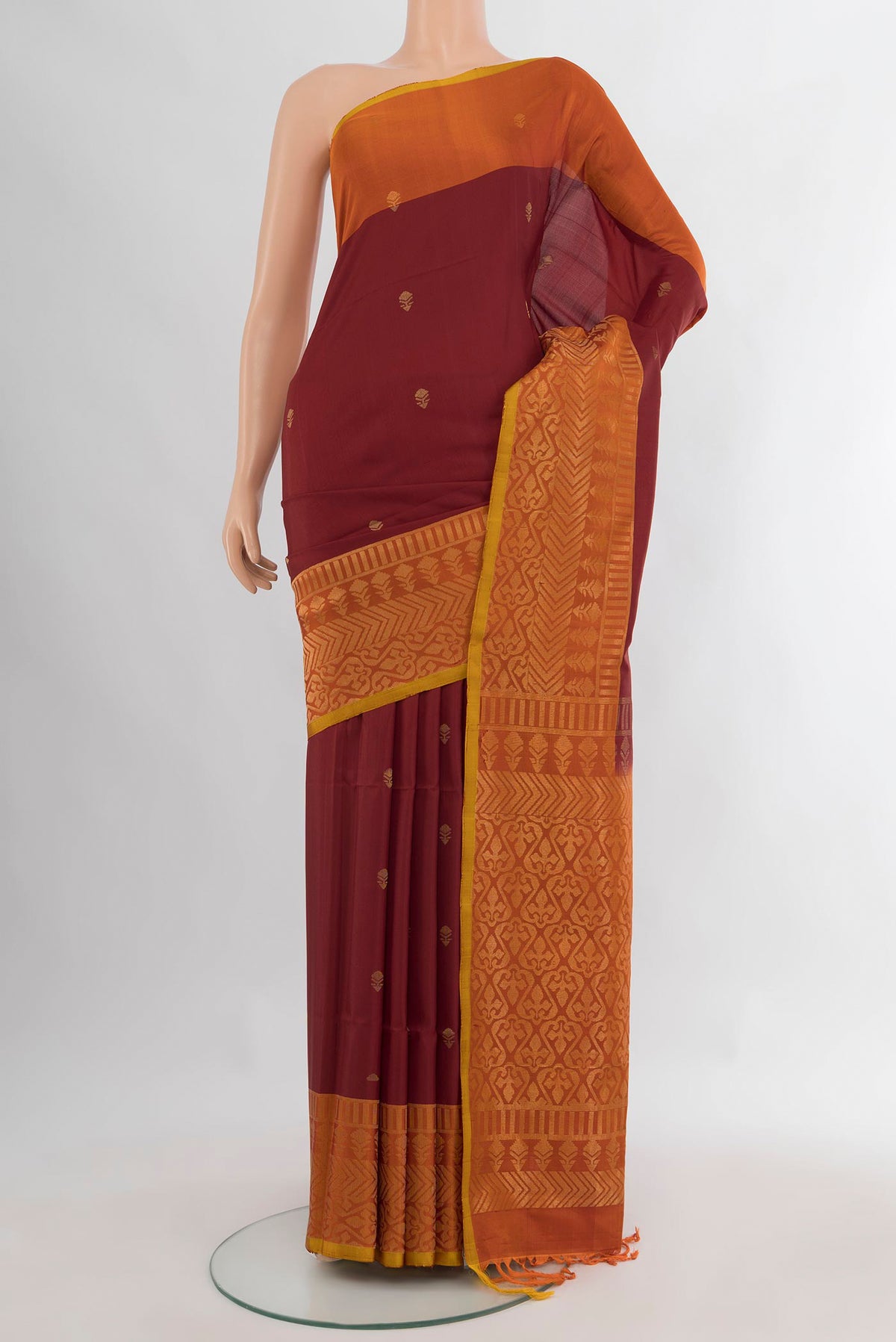 Pure Silk Maroon Soft Saree with Zari Butta on the body and Fancy Border.  displayed on a mannequin