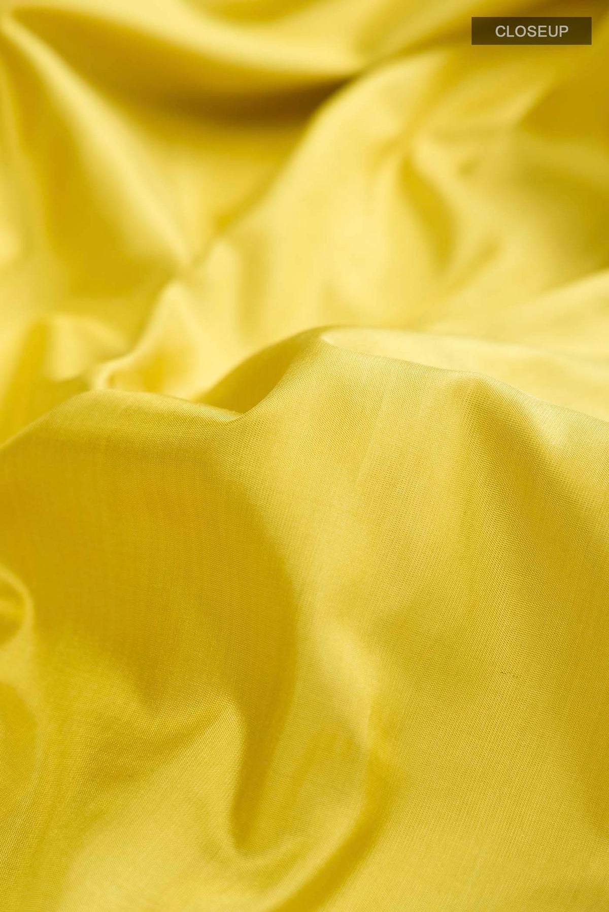Close up of Yellow Banarasi Silk Saree with Plain Body and Zari Border displaying folds