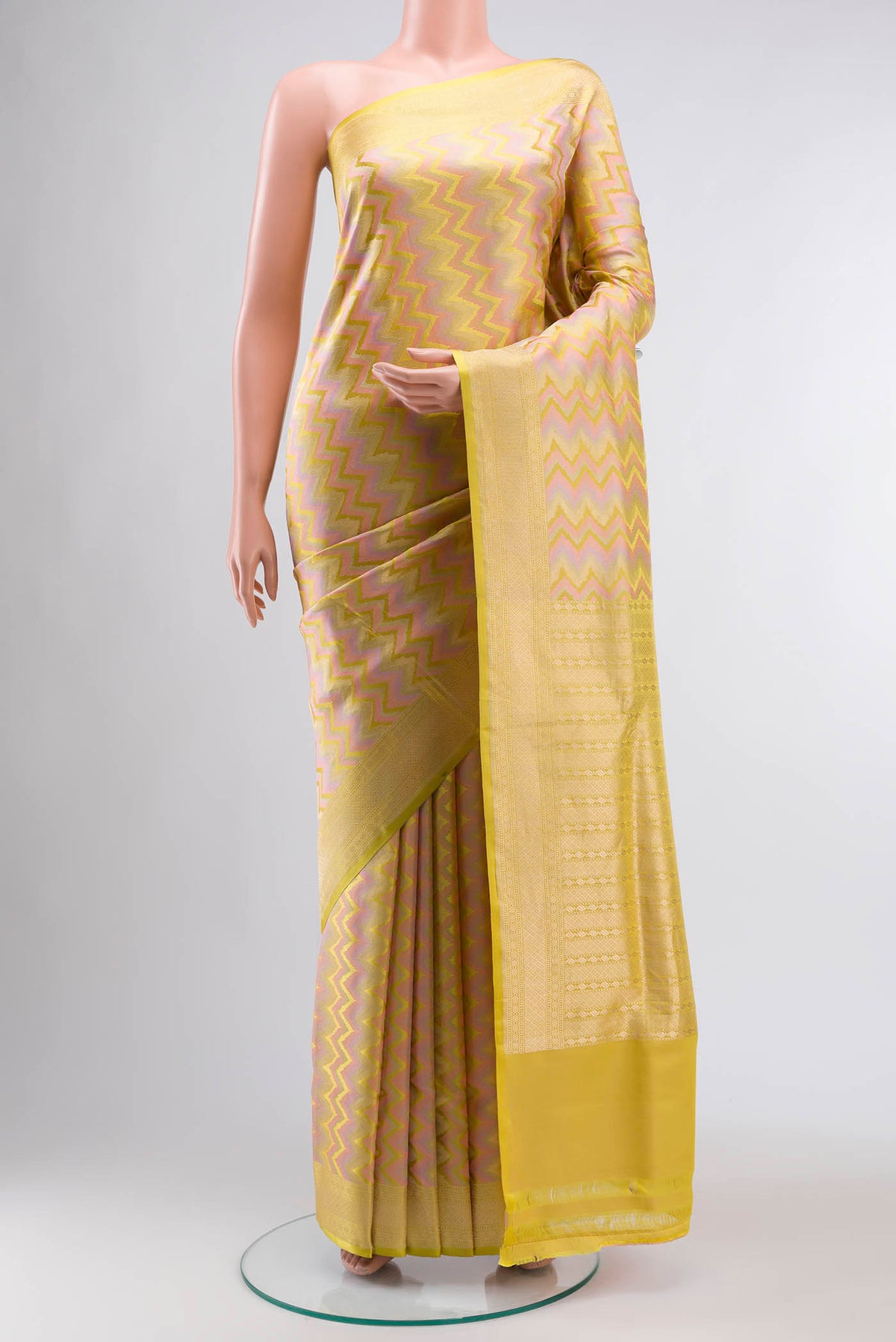 Yellow Banarasi Silk Saree with Zig Zag design on the body and Zari Border displayed on a mannequin