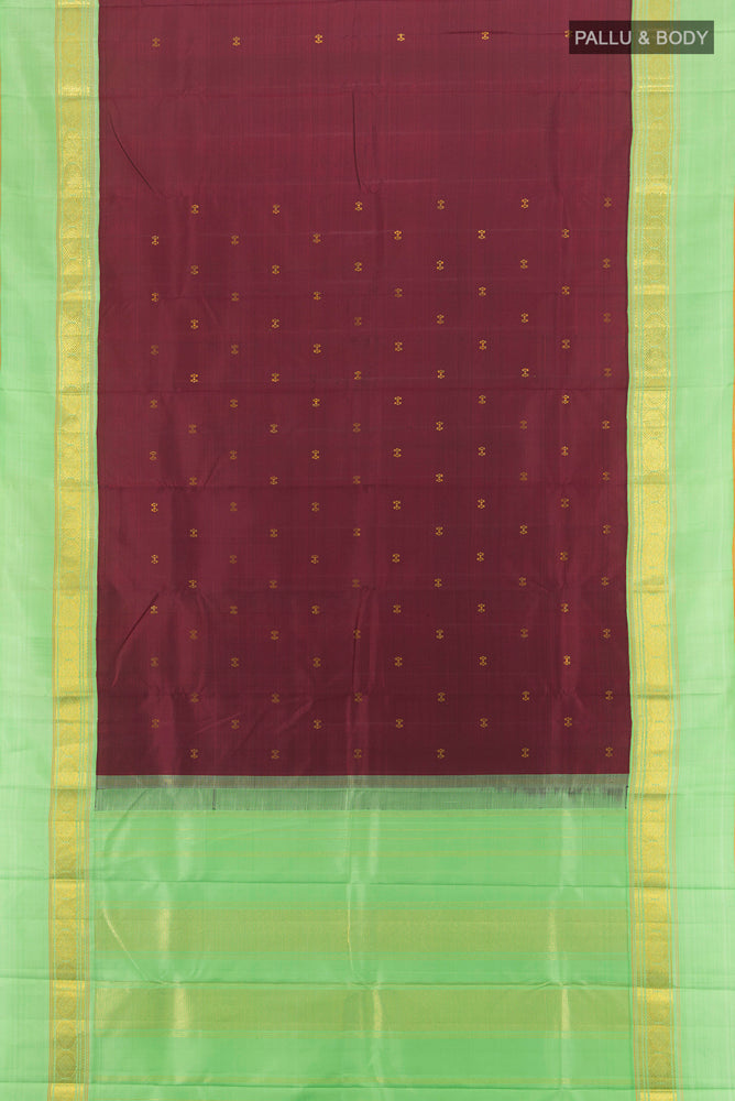 Flat view of Maroon Kanjivaram Silk Saree with Zari Butta on the body and Silk Border. 