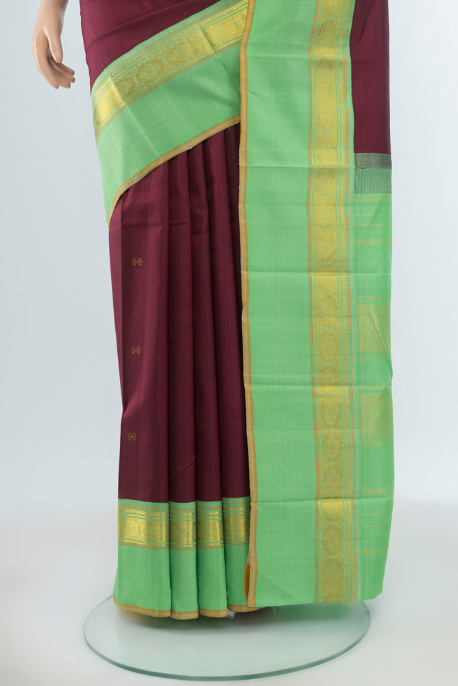 Pleats and pallu of Maroon Kanjivaram Silk Saree with Zari Butta on the body and Silk Border. 