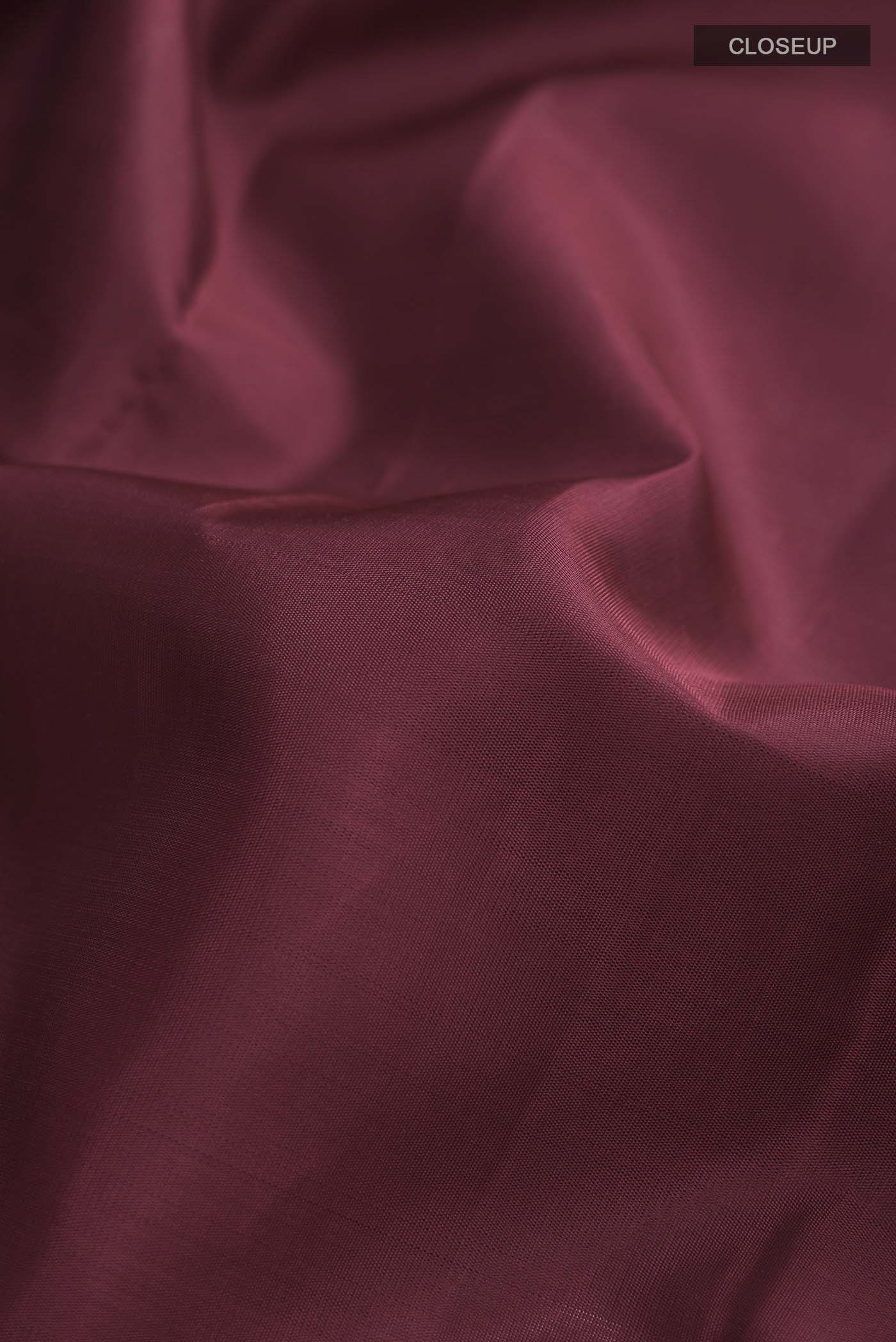 Close up of Maroon Kanchipuram Silk Saree with Plain Body and Zari Border displaying folds
