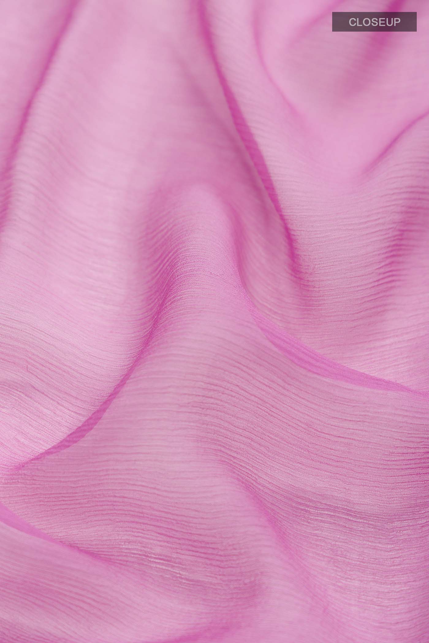 Close up of Pink Chiffon Saree with Plain Body and Zari Border displaying folds