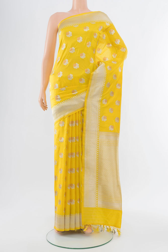 Lemon Yellow Banarasi Katan Silk Saree with Zari Butta on the body and Silk Border.  displayed on a mannequin
