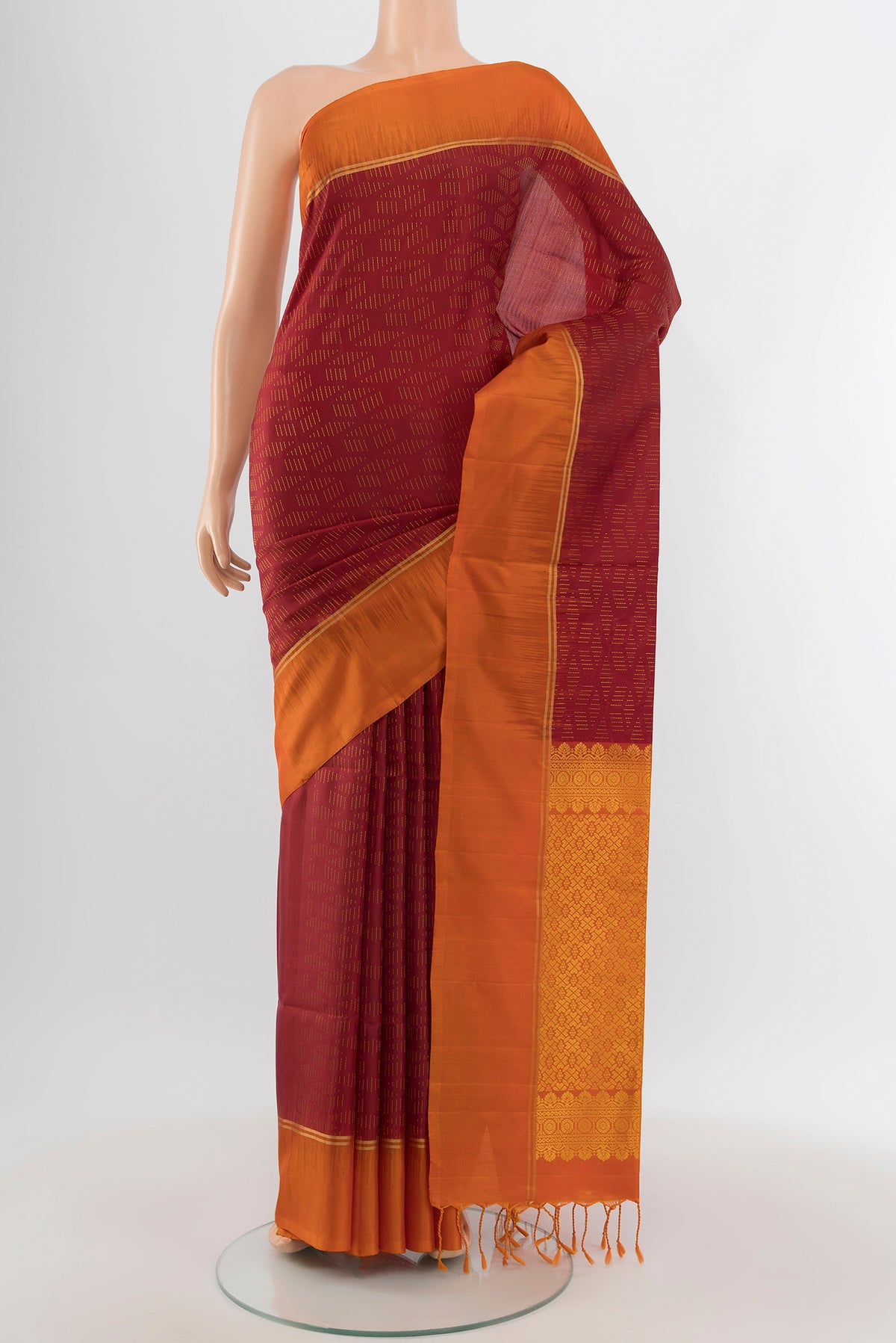 Maroon Soft Silk Saree with Zari Butta on the body and Plain Border.  displayed on a mannequin