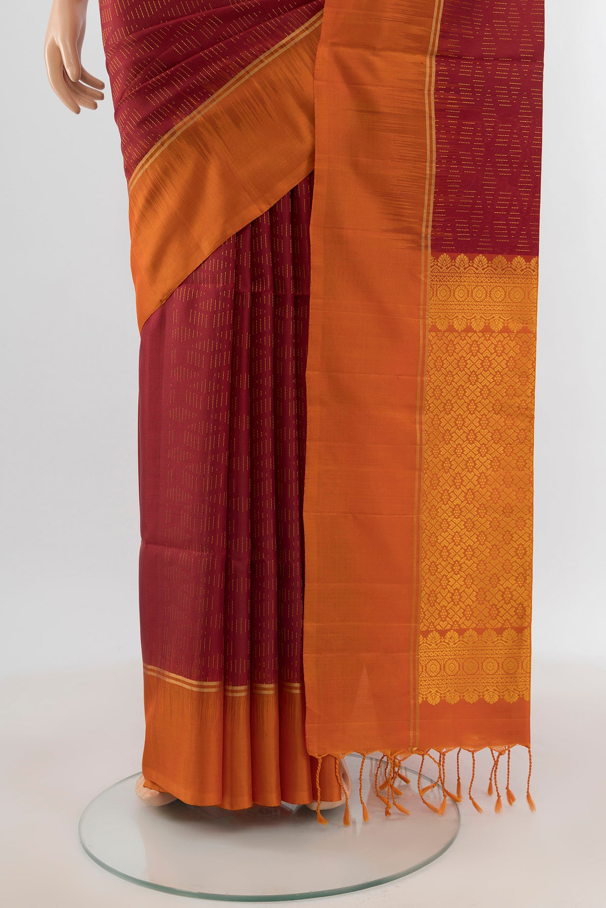 Pleats and pallu of Maroon Soft Silk Saree with Zari Butta on the body and Plain Border. 