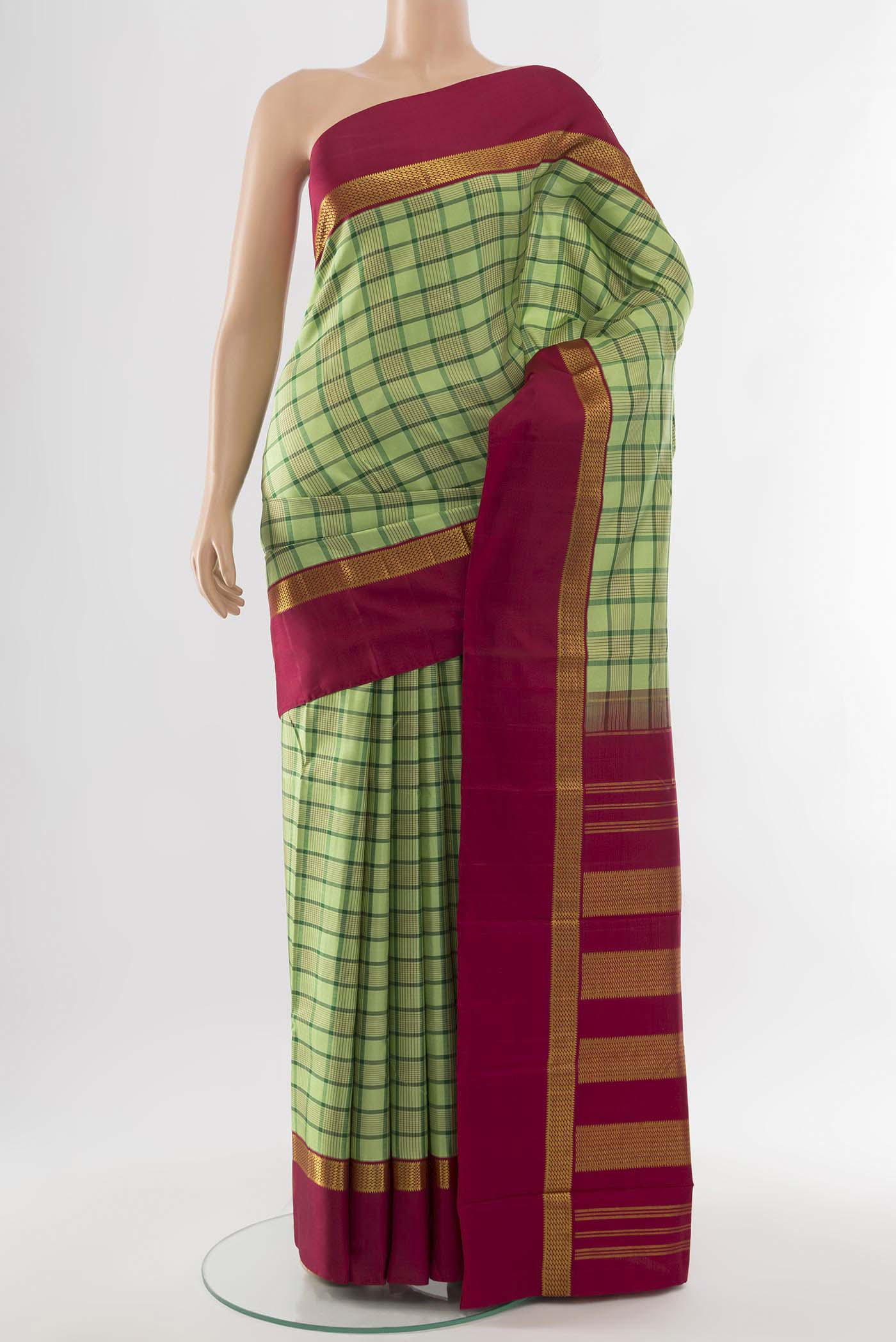 Light Green Kanjivaram Silk Saree with Zari Butta on the body and Silk Border.  displayed on a mannequin