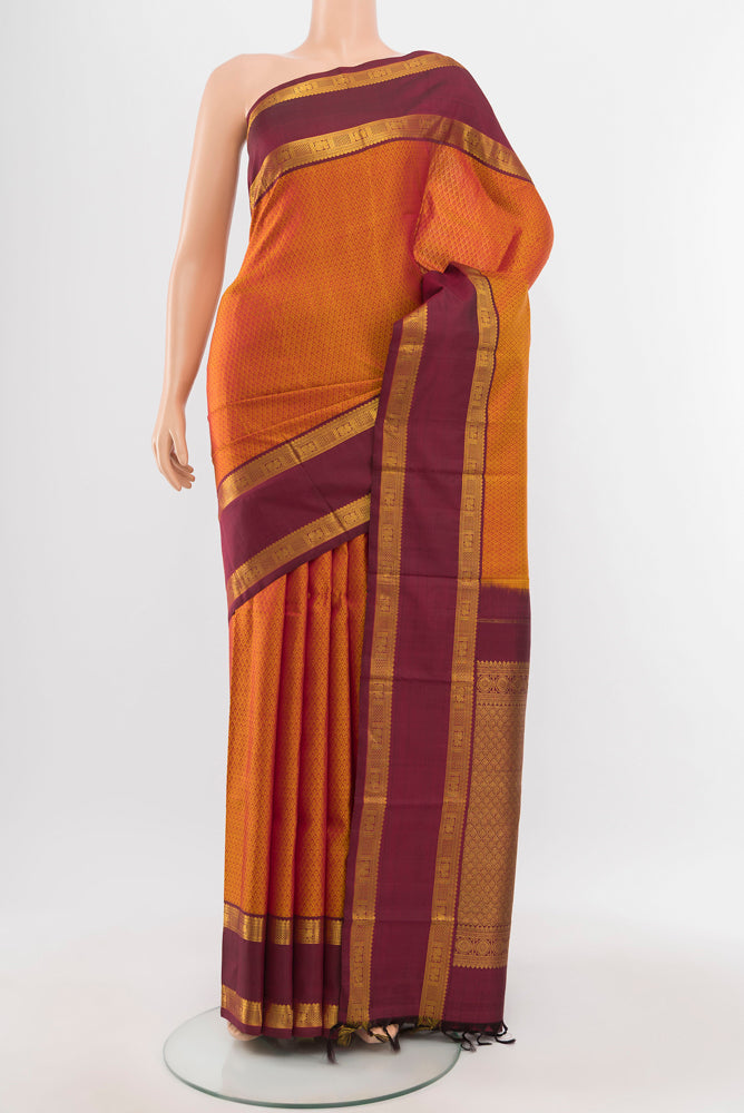 Mustard Kanjivaram Silk Saree with Zari Butta on the body and Silk Border.  displayed on a mannequin