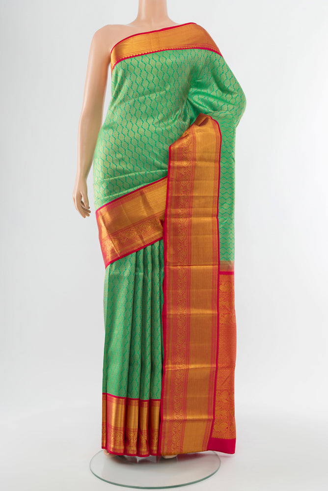 Light Green Kanjivaram Silk Saree with Zari Butta on the body and Silk Border.  displayed on a mannequin