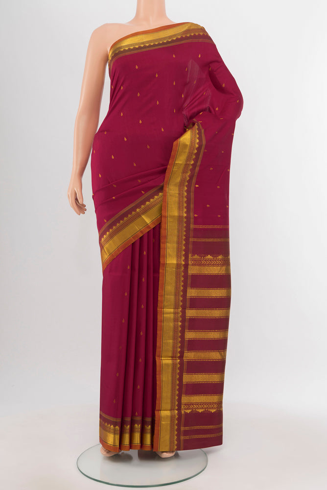 Maroon Kanchipuram Silk Saree with Zari Butta on the body and Silk Border.  displayed on a mannequin