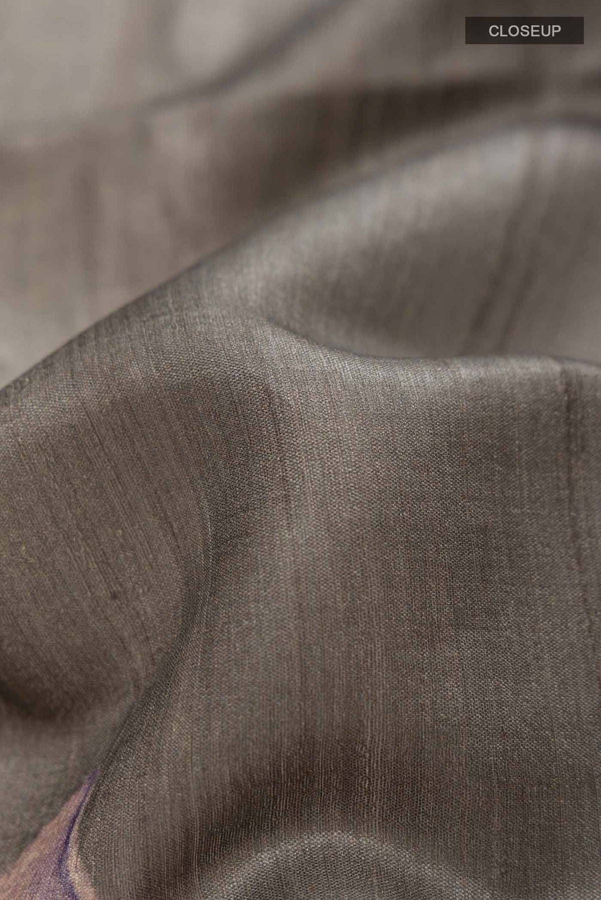 Close up of Grey Tussar Saree with Plain Body and Zari Border displaying folds