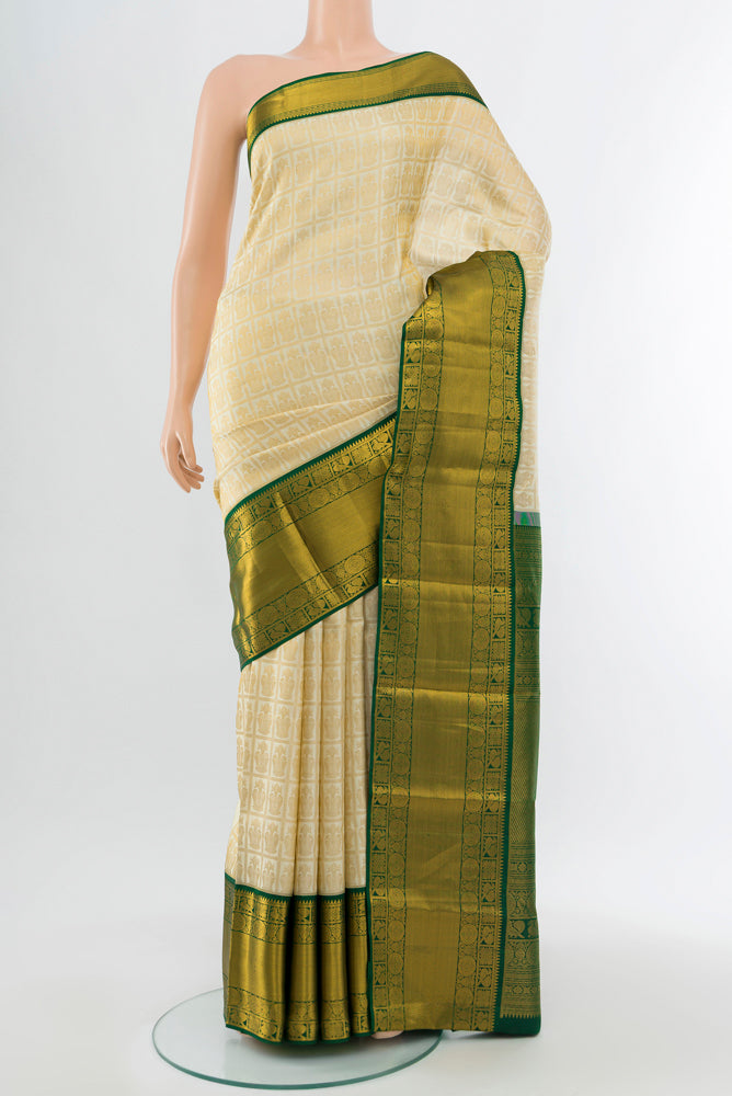 Golden Kanchipuram Silk Saree with Zari Butta on the body and Silk Border.  displayed on a mannequin