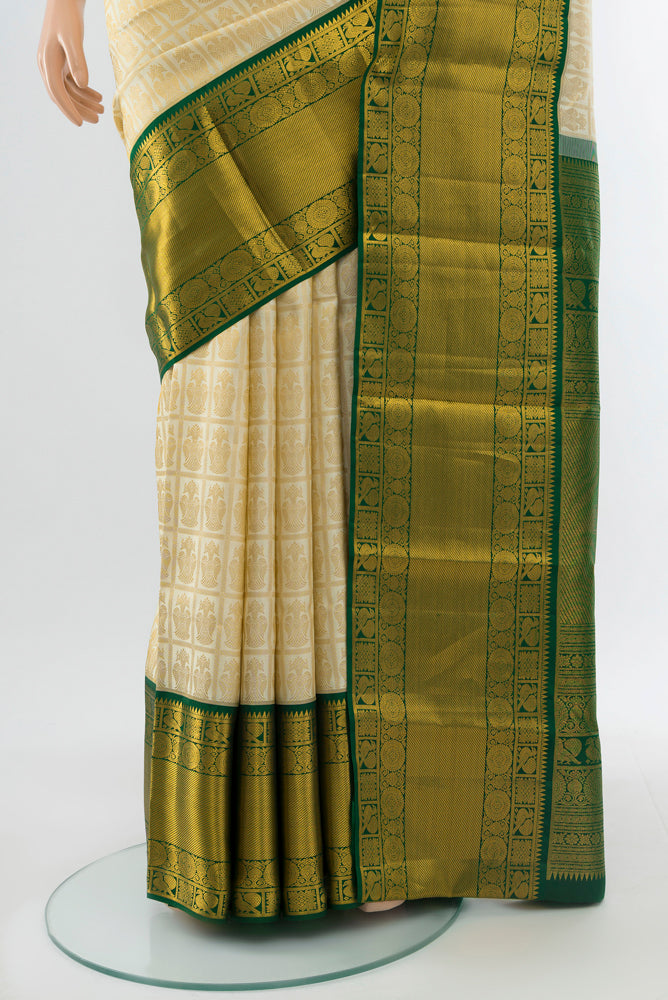 Pleats and pallu of Golden Kanchipuram Silk Saree with Zari Butta on the body and Silk Border. 