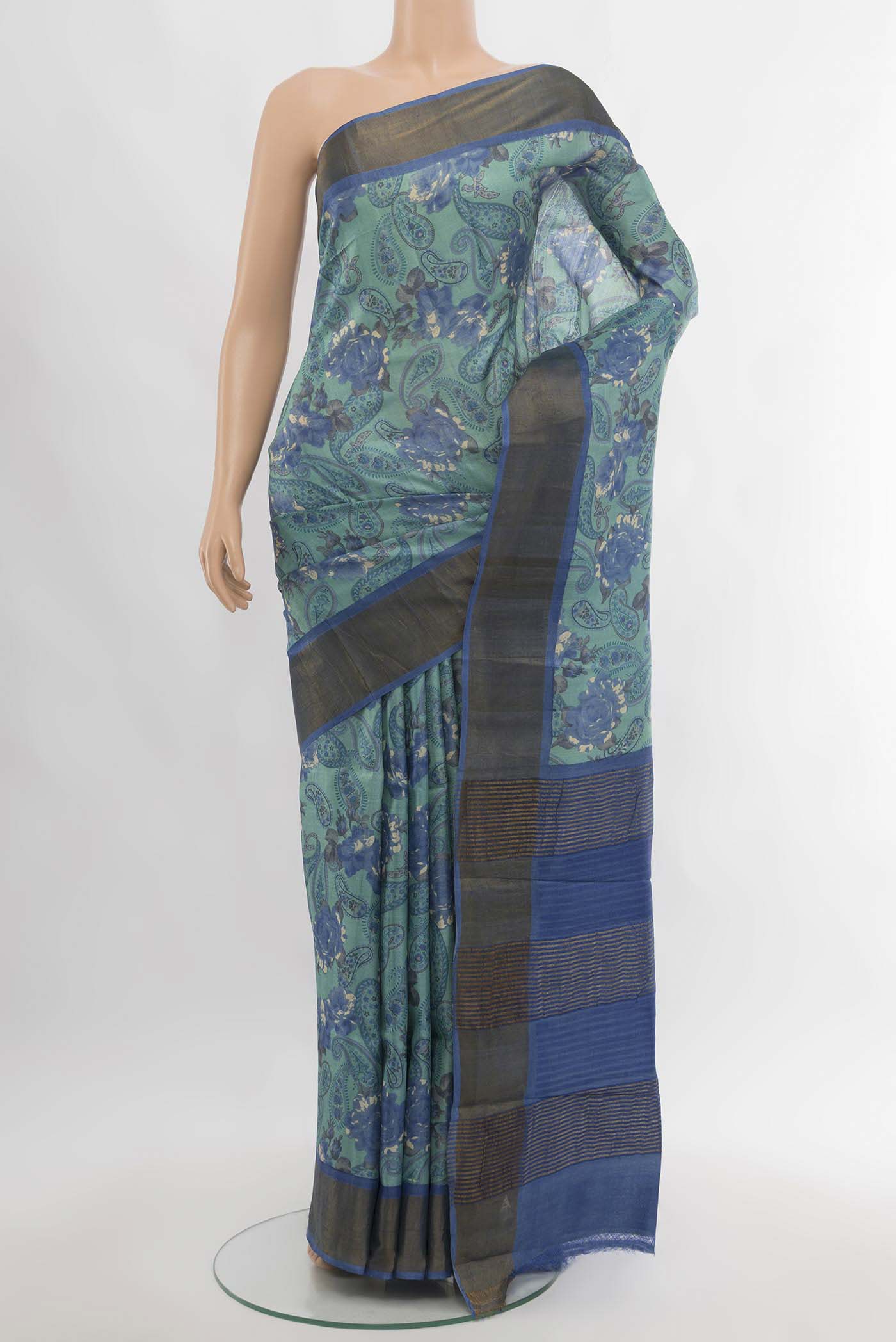 Sky Blue Tussar Silk Saree with Floral Print on the body and Silk Border.  displayed on a mannequin