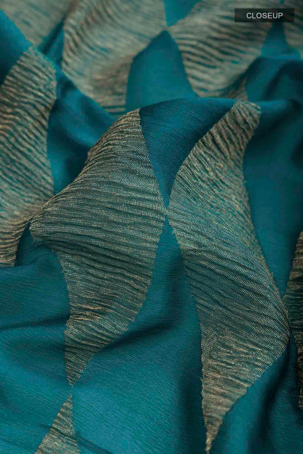 Close up of Teal Mysore Georgette Saree with Zari Butta on the body and Zari Border displaying folds