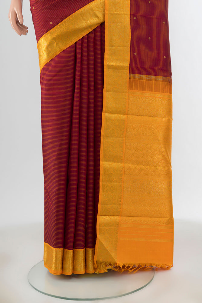 Pleats and pallu of Maroon Kanchipuram Silk Saree with Zari Butta on the body and Silk Border. 