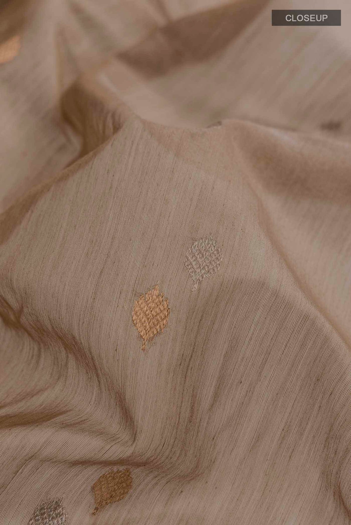 Close up of Beige Chanderi Silk Cotton Saree with Zari Butta on the body and Zari Border displaying folds