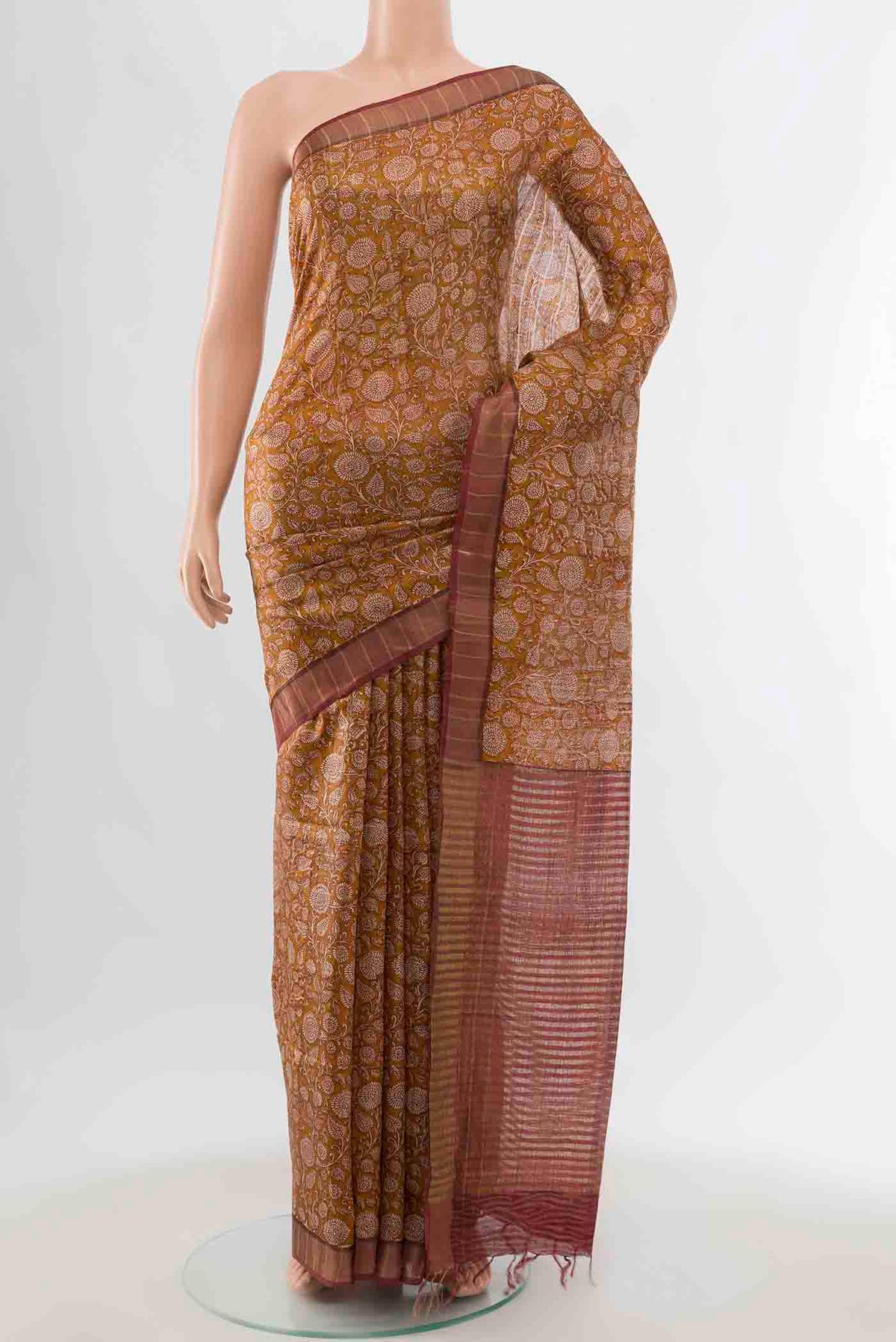 Mustard Tussar Silk Saree with Floral Print on the body and Zari Border displayed on a mannequin
