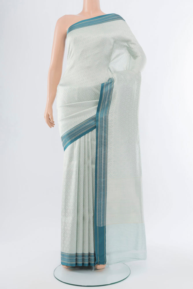 Silver Banarasi Katan Silk Saree with Zari Butta on the body and Silk Border.  displayed on a mannequin