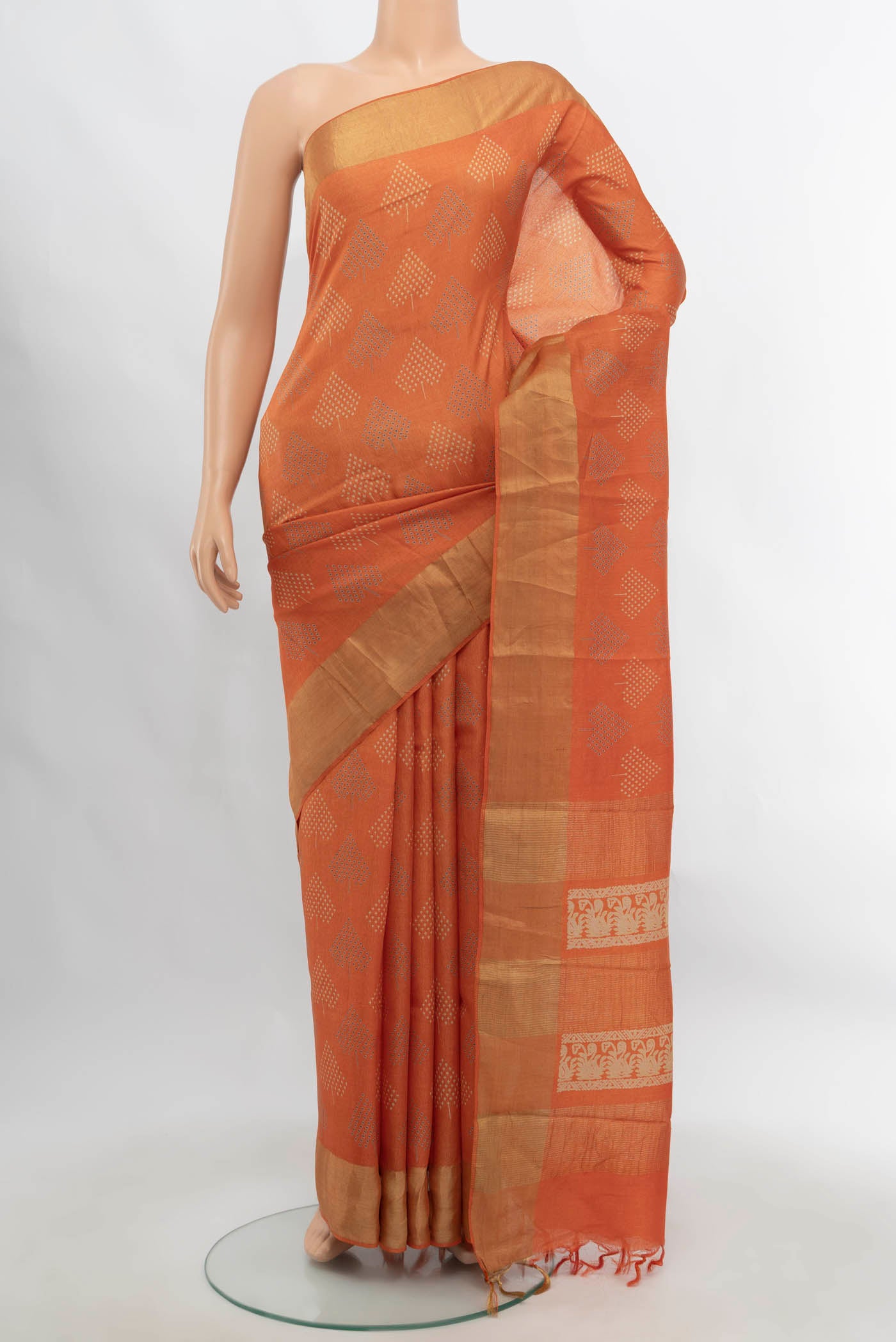 Orange Tussar Silk Saree with Zari Butta on the body and Silk Border.  displayed on a mannequin