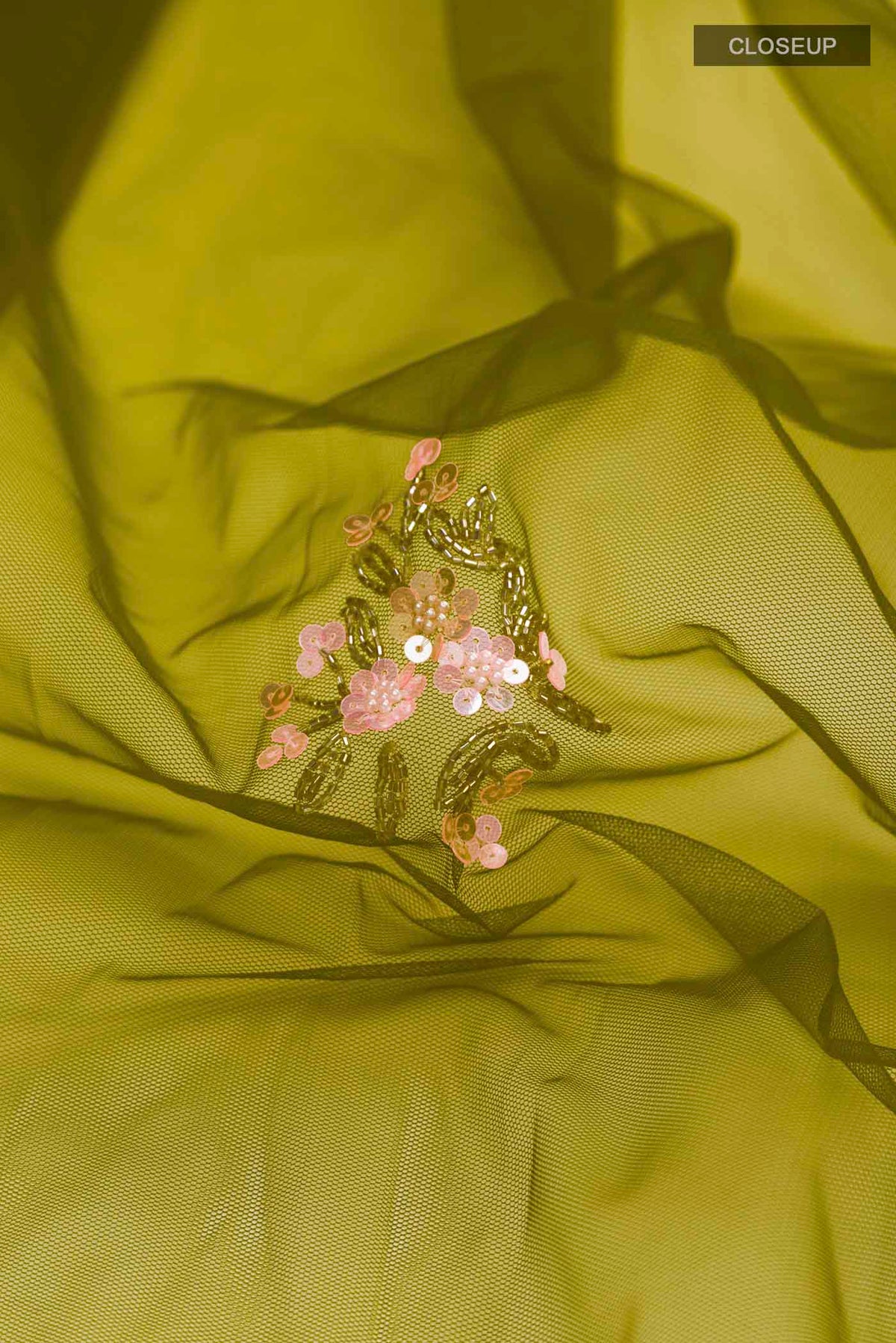 Close up of Green Embroidery Net Saree with Embroidery on the body and Embroidery Border displaying folds