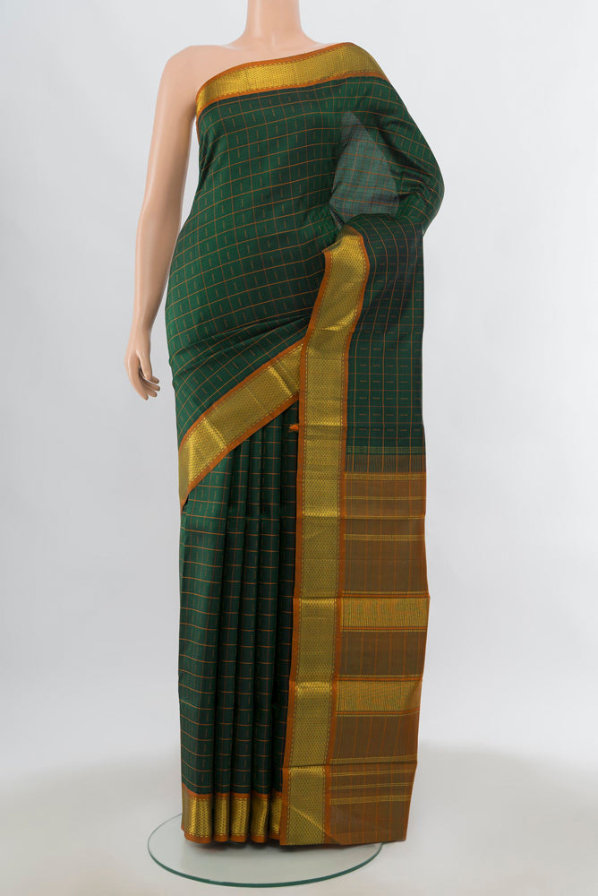 Green Kanchipuram Silk Saree with Zari Butta on the body and Silk Border.  displayed on a mannequin