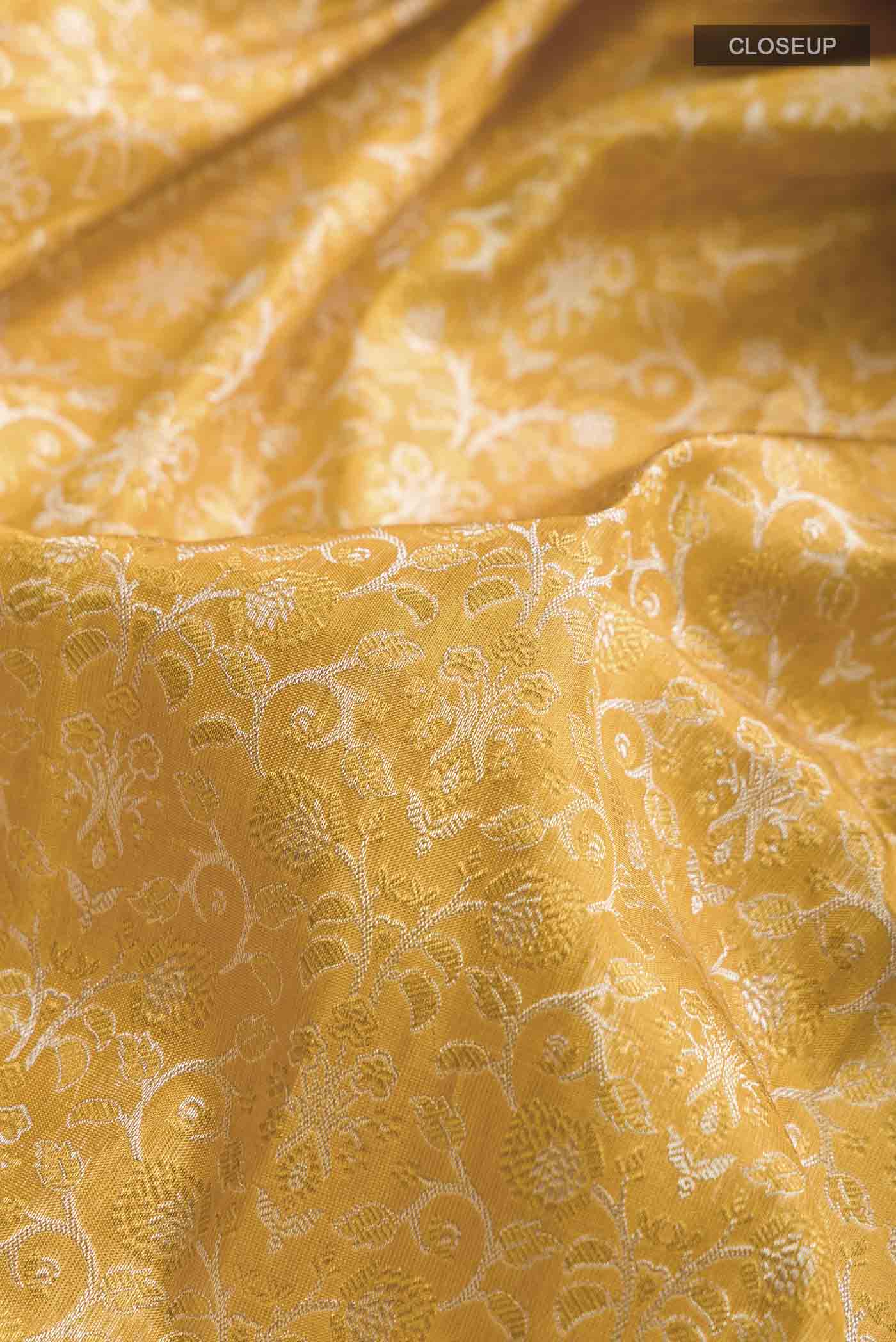 Close up of Pure Silk Pure Zari Yellow Kanchipuram Saree with Zari Brocade on the body and Zari Border displaying folds