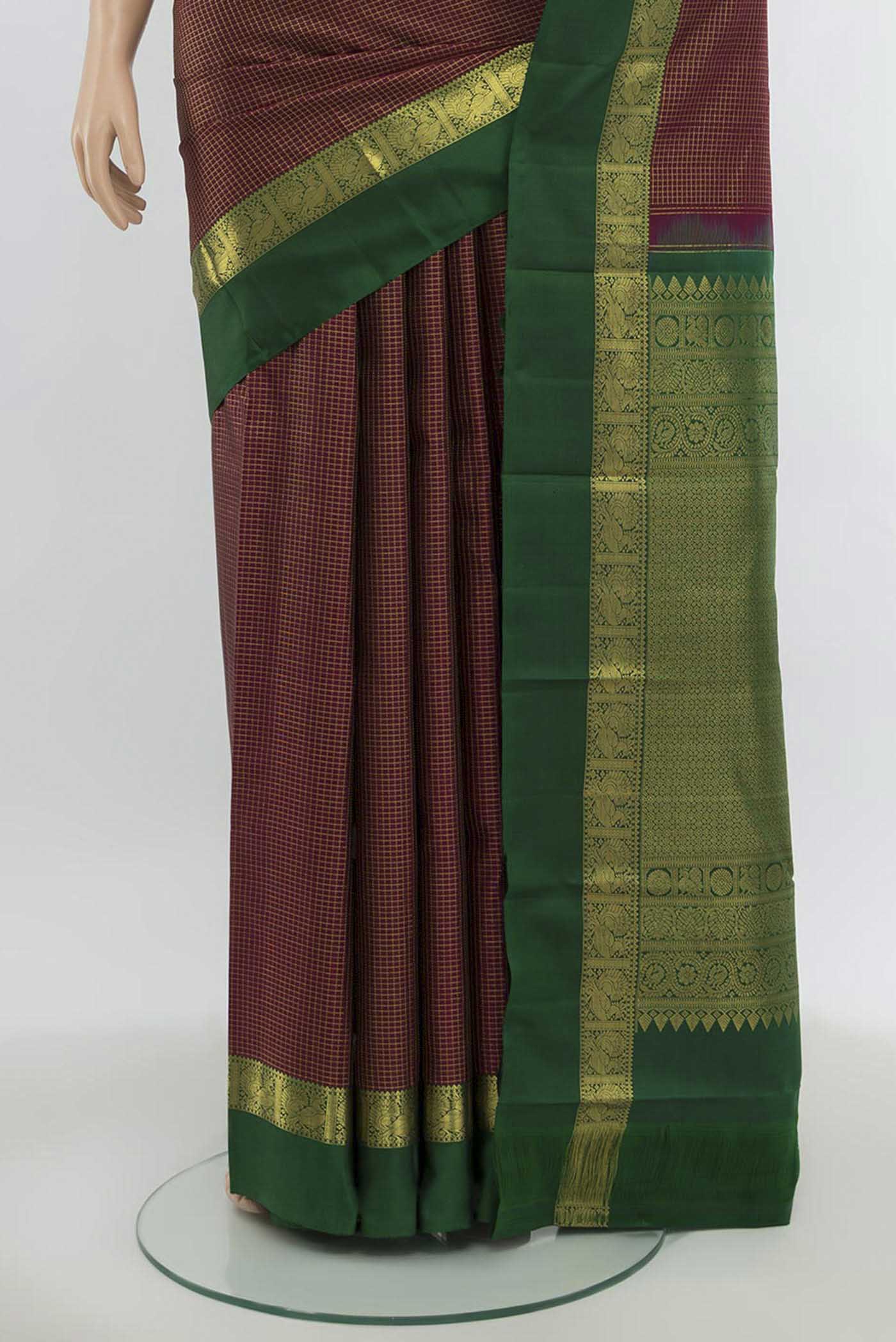 Pleats and pallu of Maroon Kanchipuram Silk Saree with Zari Butta on the body and Silk Border. 