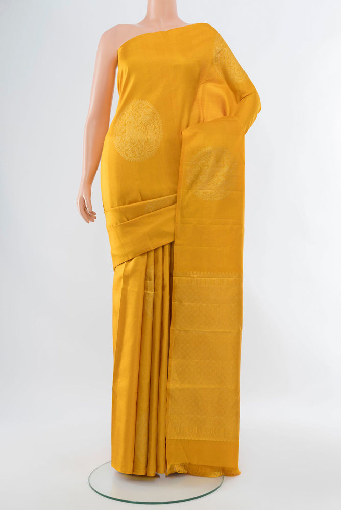 Yellow Kanjivaram Silk Saree with Zari Butta on the body and Silk Border.  displayed on a mannequin