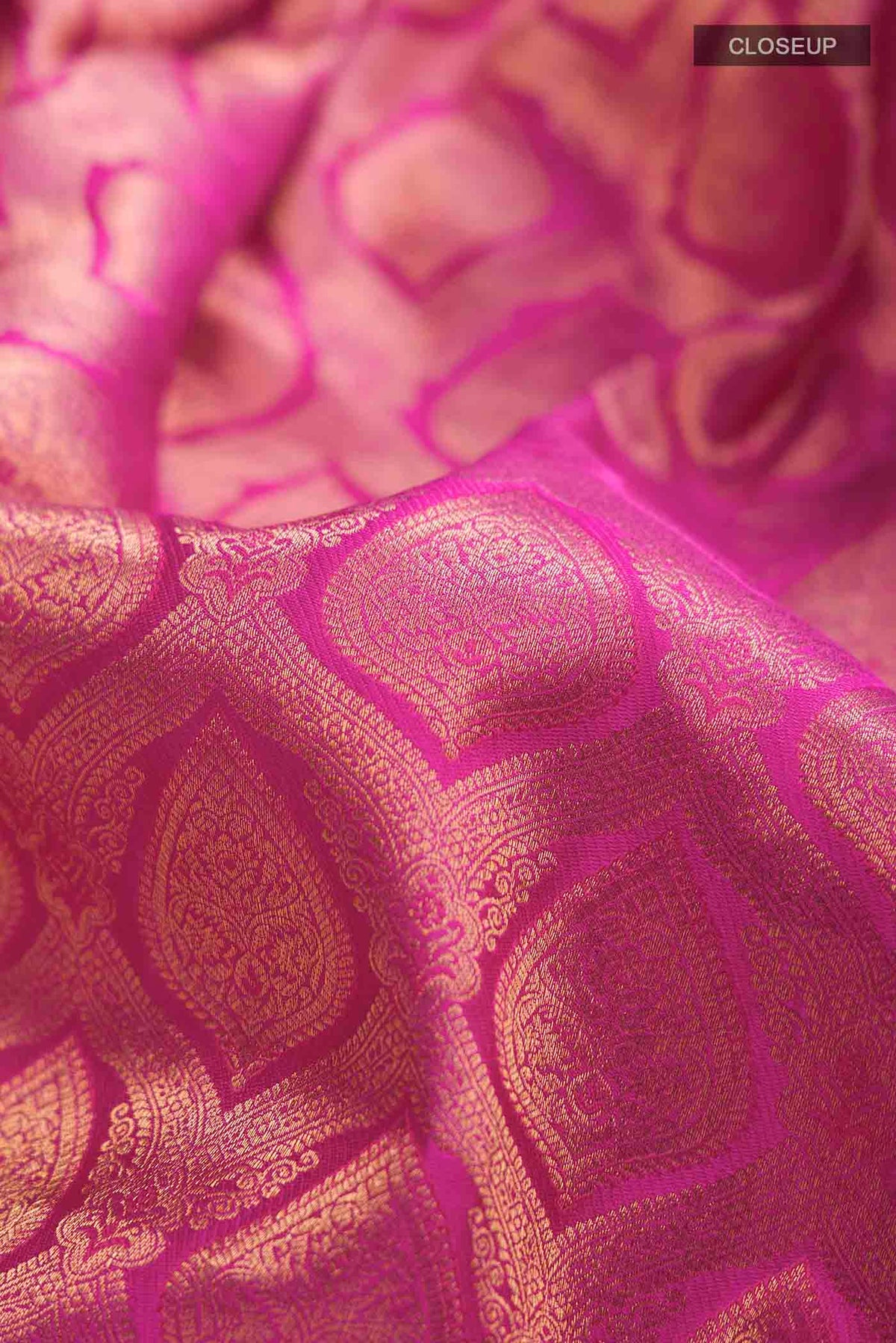 Close up of Pink Kanchipuram Silk Saree with Zari Brocade on the body and Embroidery Border displaying folds