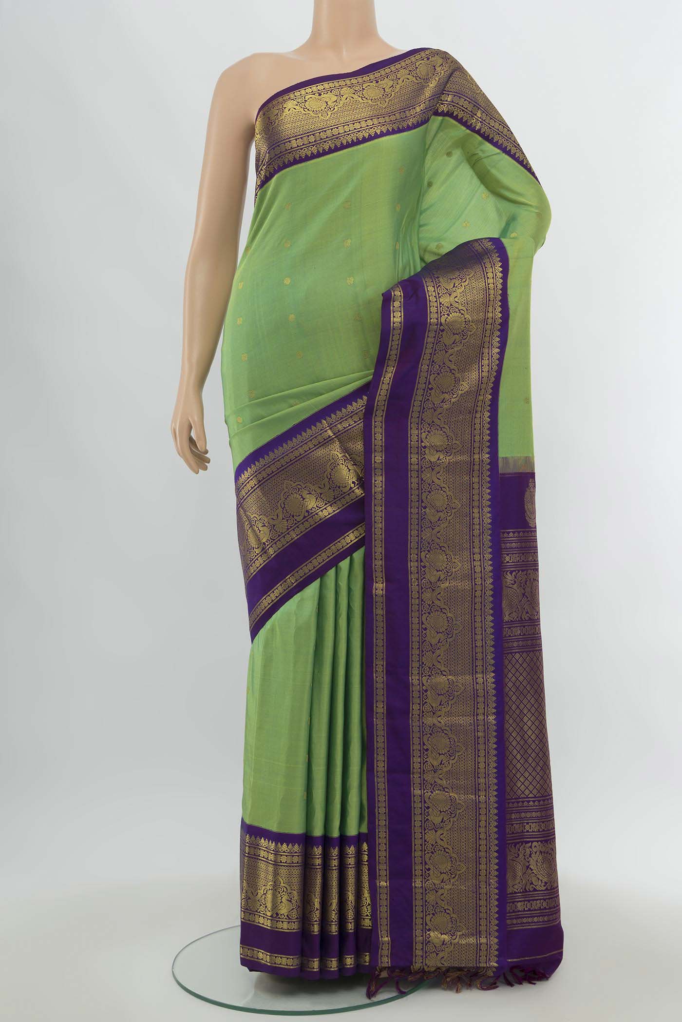 Parrot Green Gadwal Silk Saree with Zari Butta on the body and Silk Border.  displayed on a mannequin