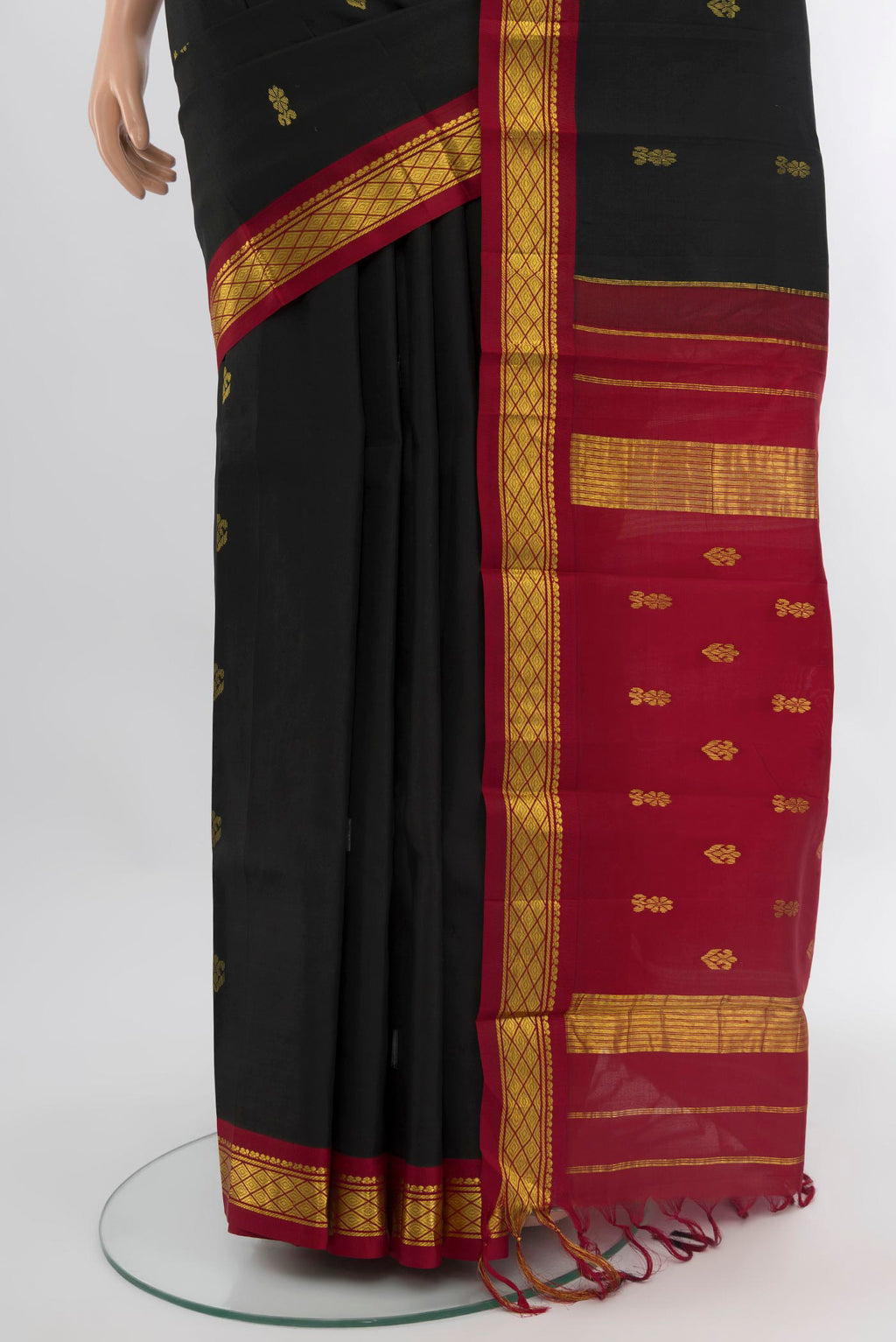 Pleats and pallu of Black Kanchipuram Silk Saree with Zari Butta on the body and One Side Border. 