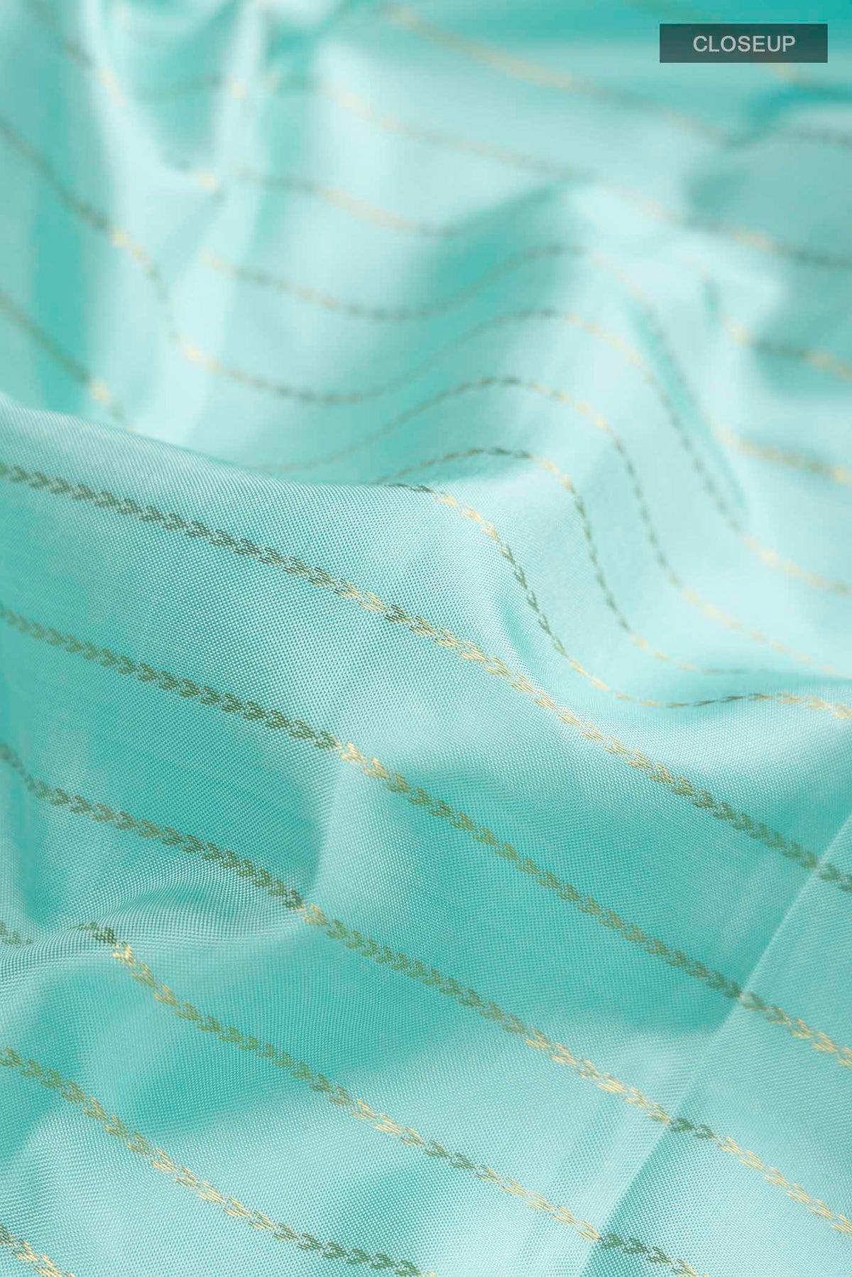 Close up of Pure Silk Pure Zari Turquoise Kanchipuram Saree with Zari Butta on the body and Zari Border displaying folds