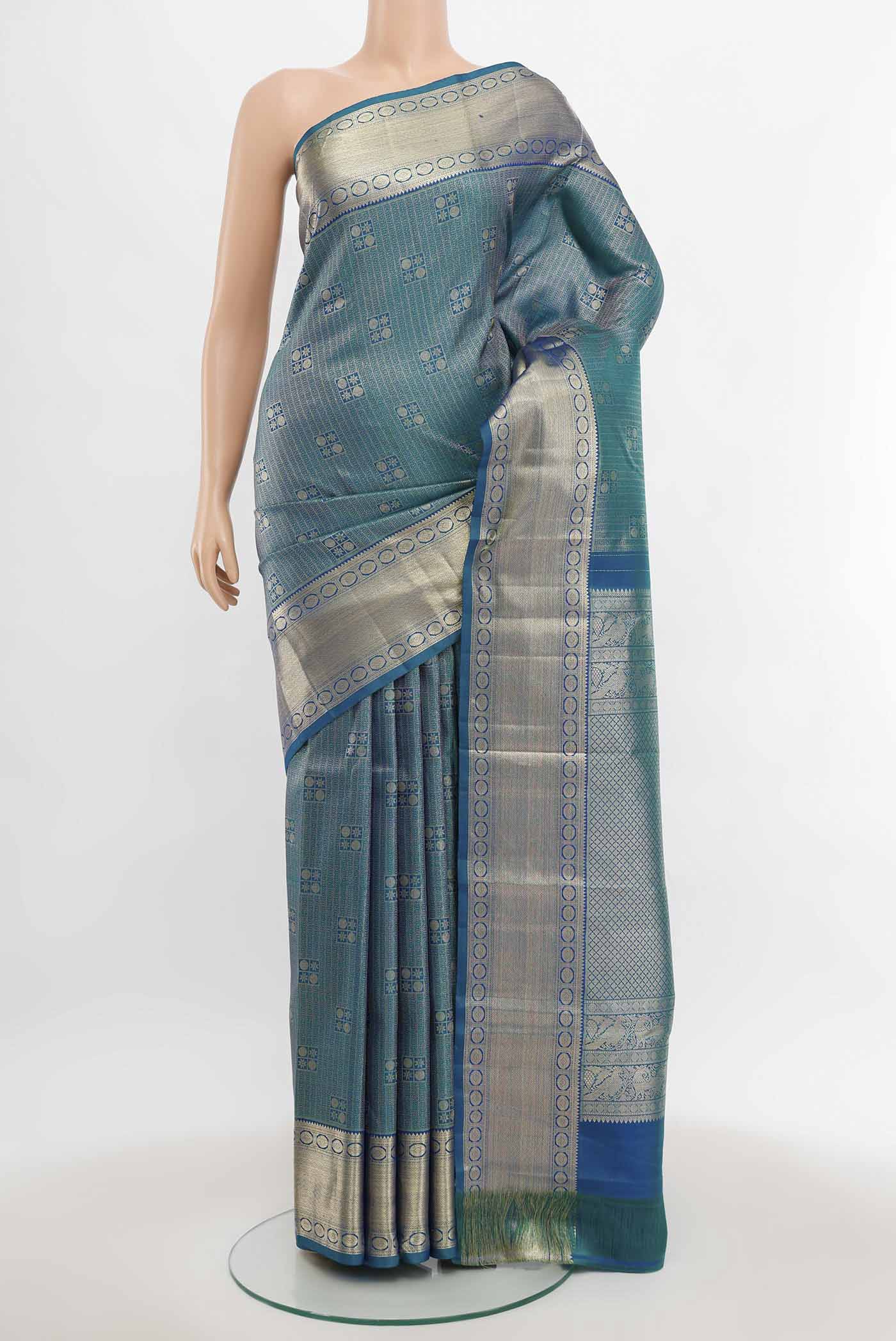 Peacock Blue Kanchipuram Silk Saree with Zari Butta on the body and Silk Border.  displayed on a mannequin