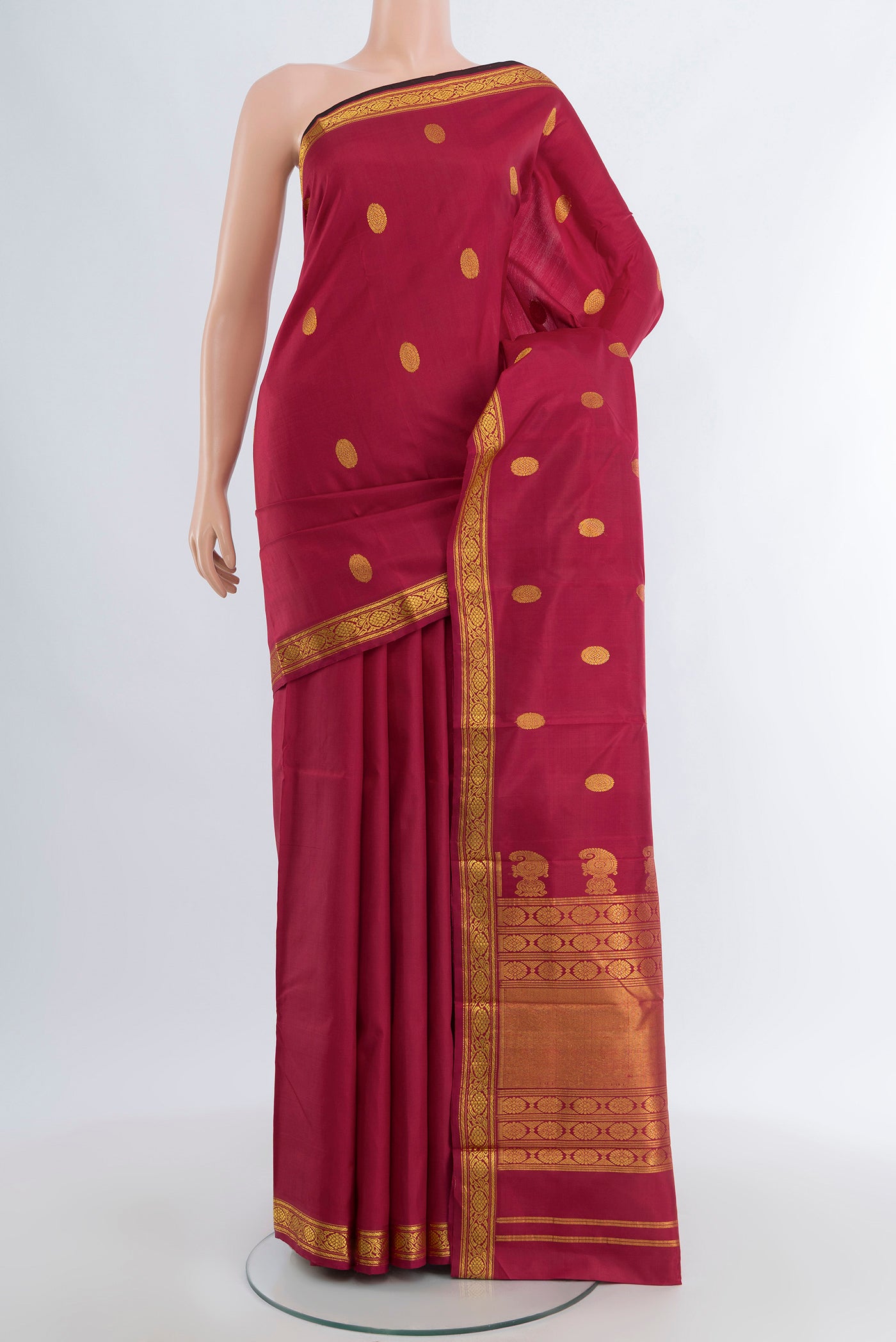 Maroon Kanjivaram Silk Saree with Zari Butta on the body and Zari Border.  displayed on a mannequin
