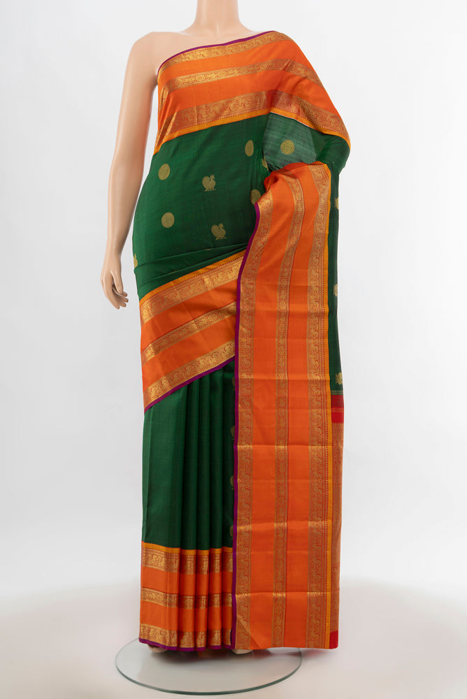 Bottle Green Kanjivaram Silk Saree with Zari Butta on the body and Silk Border.  displayed on a mannequin
