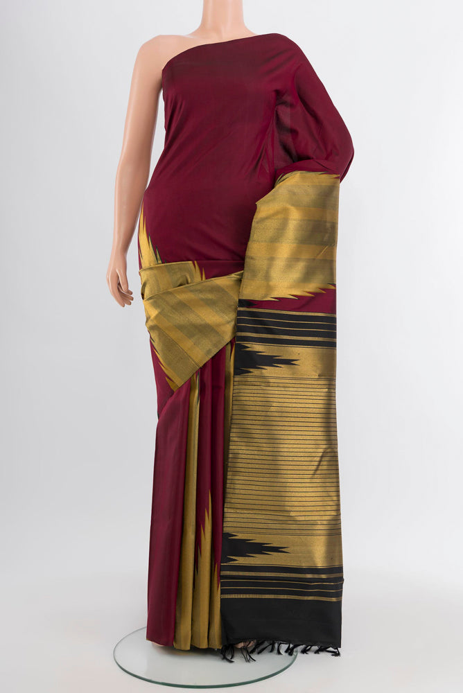 Maroon Kanjivaram Silk Saree with Zari Butta on the body and Silk Border.  displayed on a mannequin