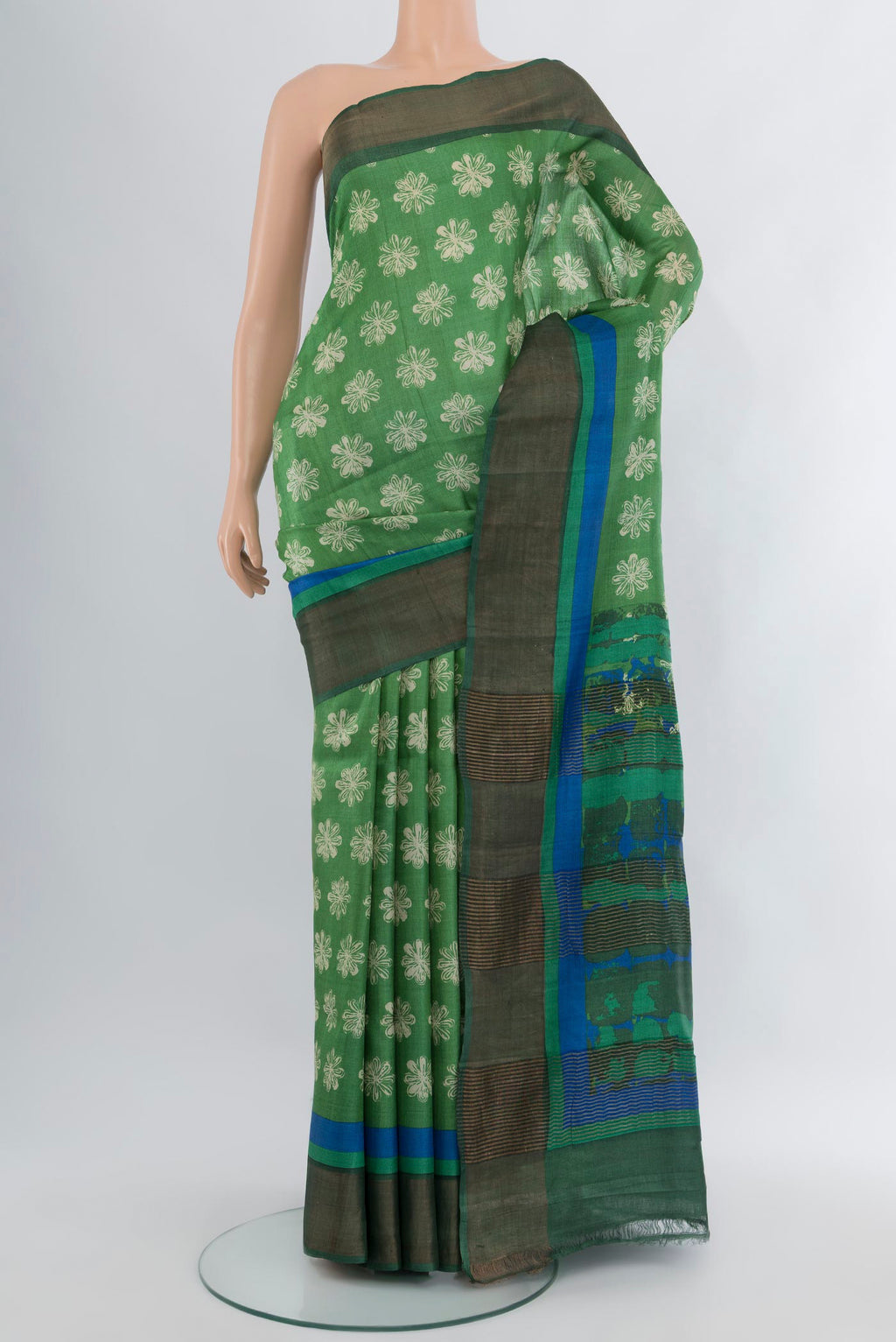 Pista Green Tussar Silk Saree with Floral Print on the body and Zari Border.  displayed on a mannequin