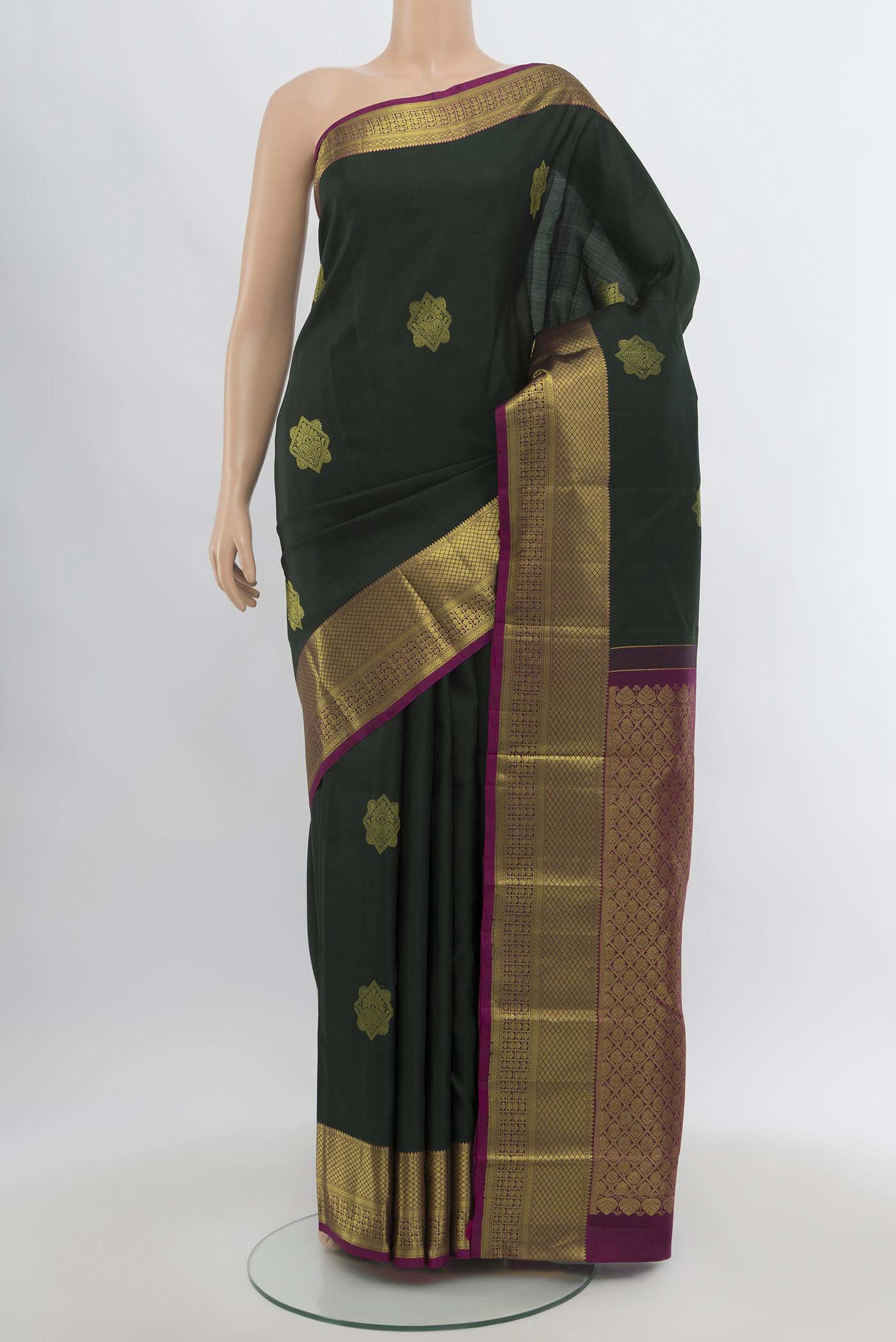Green Kanchipuram Silk Saree with Zari Butta on the body and Silk Border.  displayed on a mannequin